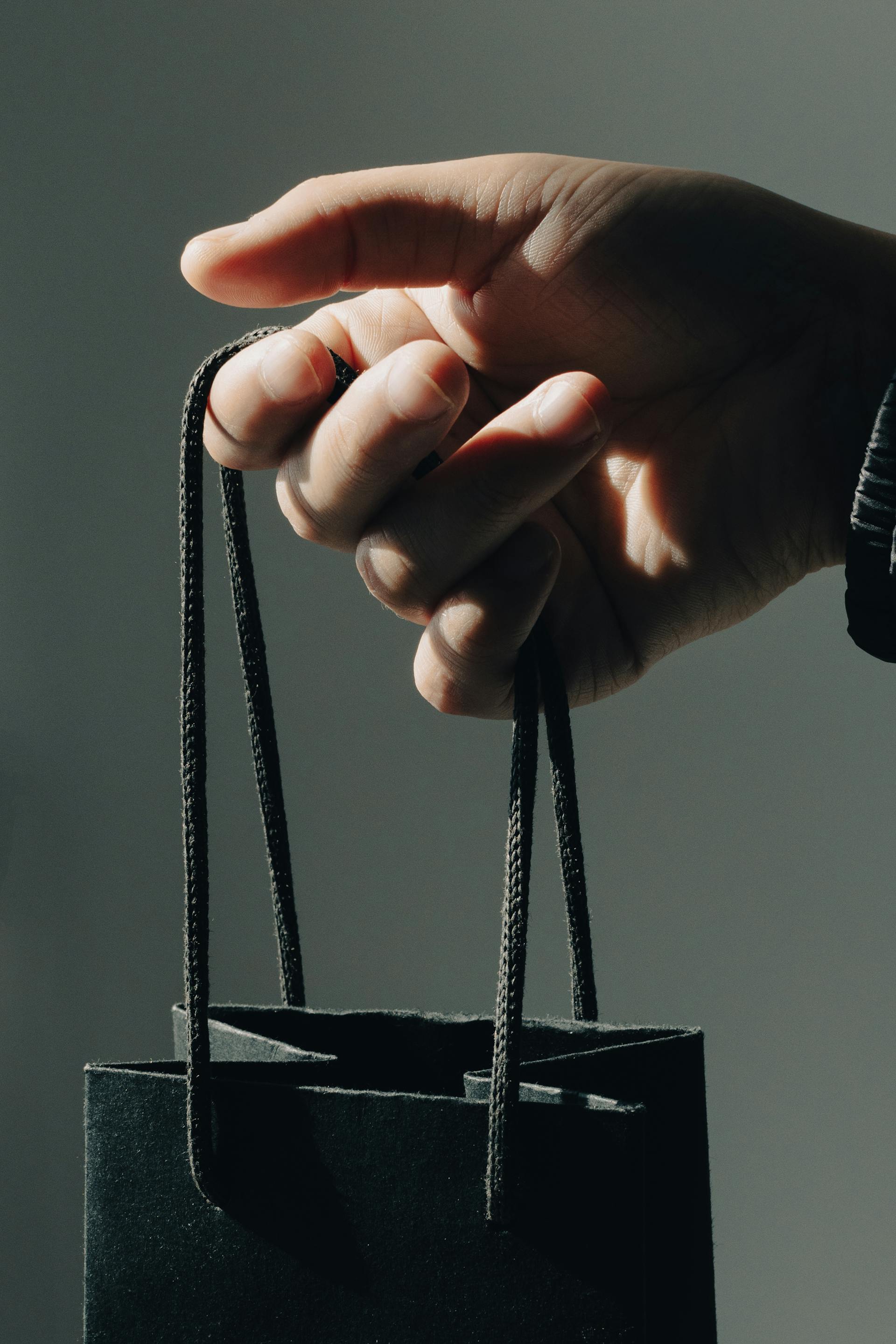 Un homme tenant un sac-cadeau | Source : Pexels