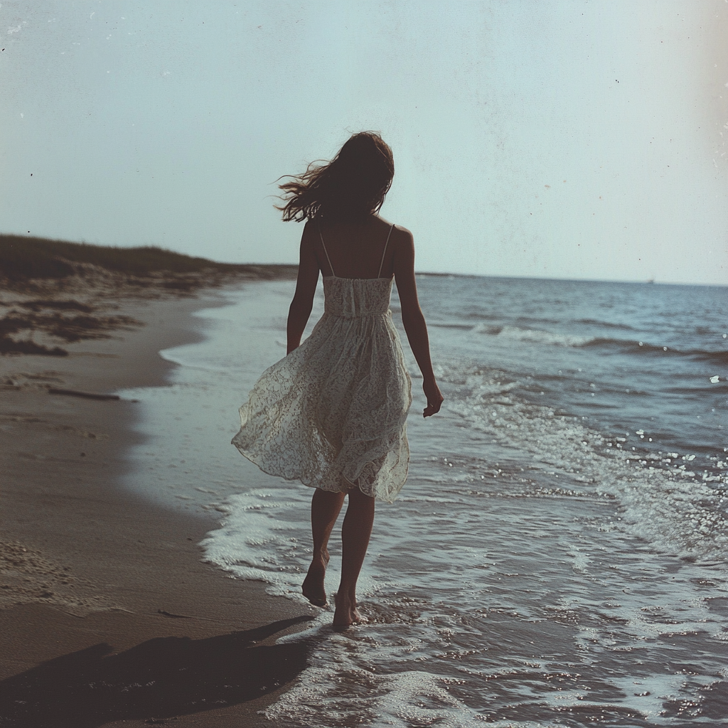 Une femme marchant au bord de l'océan | Source : Midjourney