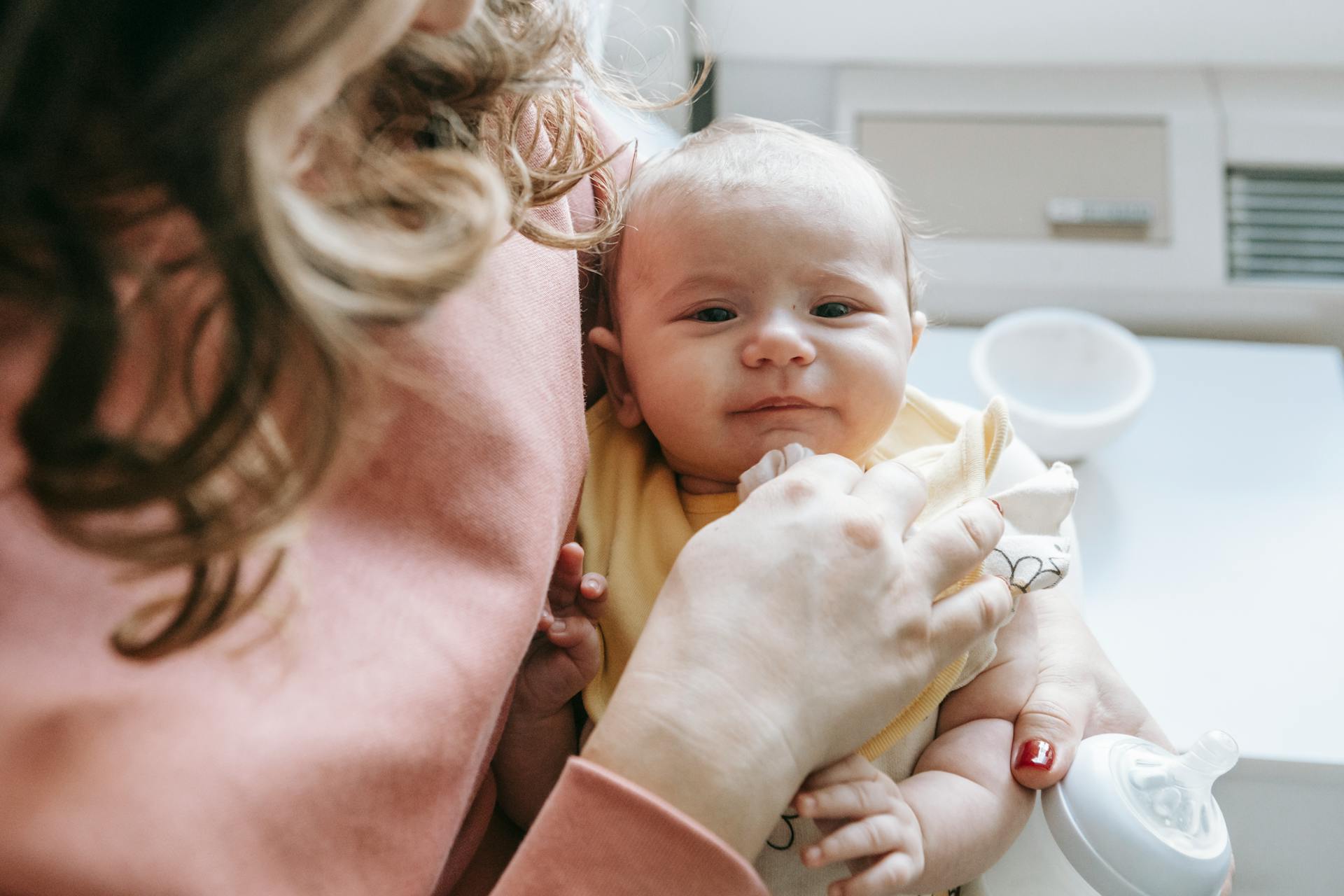 Une femme tenant un bébé et un biberon | Source : Pexels