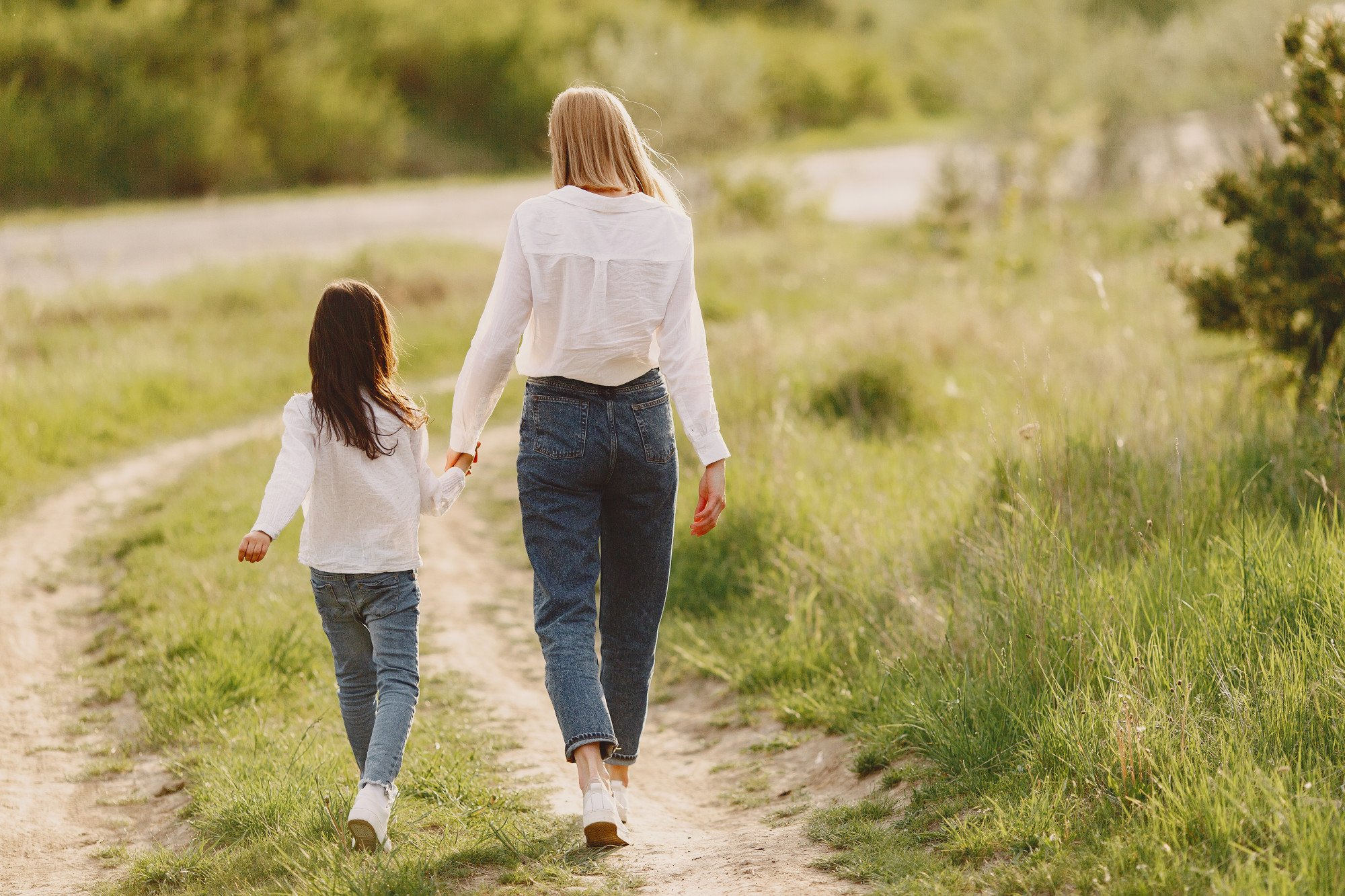 Une femme et un enfant qui se tiennent par la main tout en s'éloignant | Source : Pexels