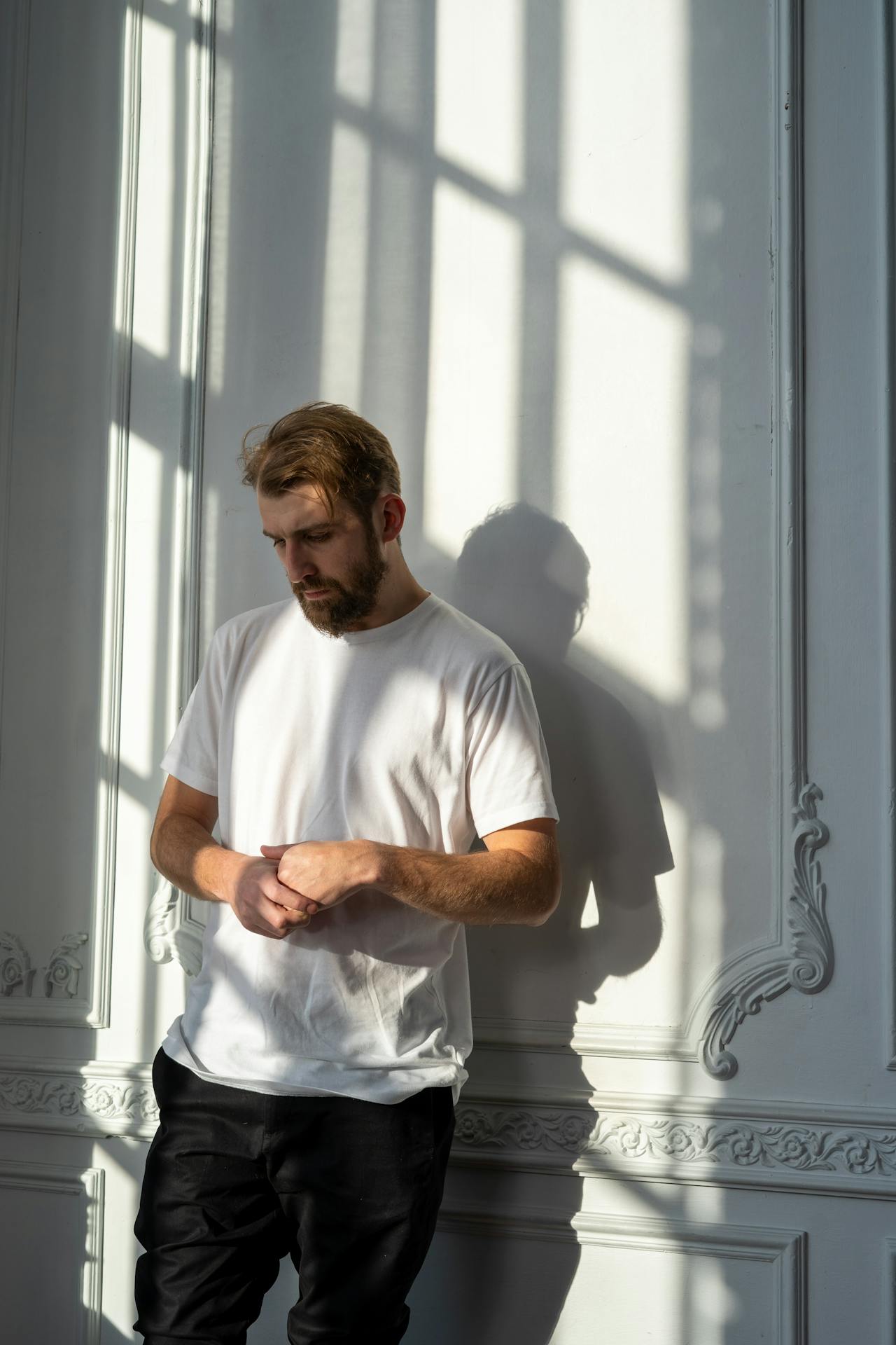 Un homme triste debout à côté d'un mur | Source : Pexels