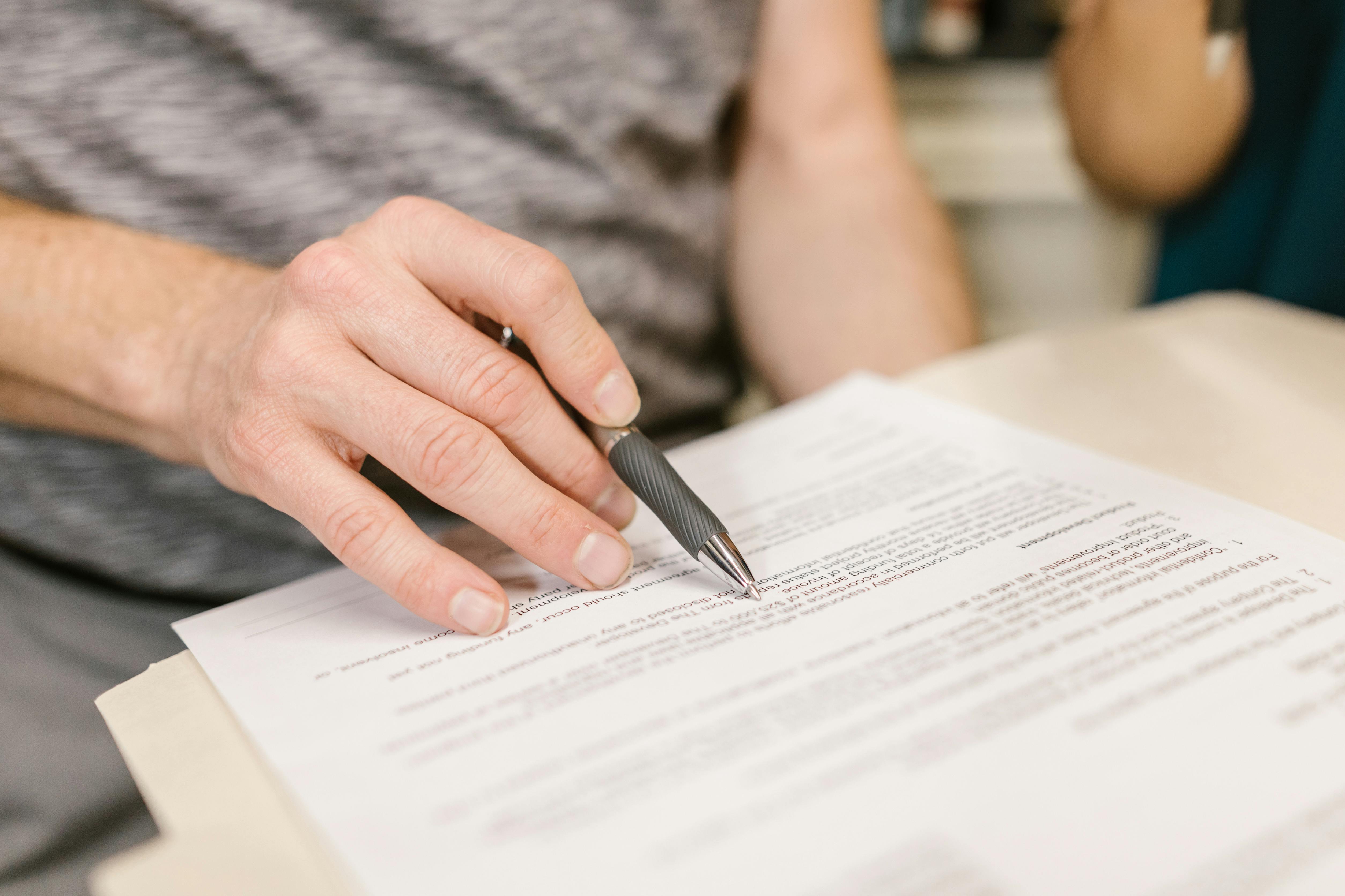 Une personne signant des documents | Source : Pexels