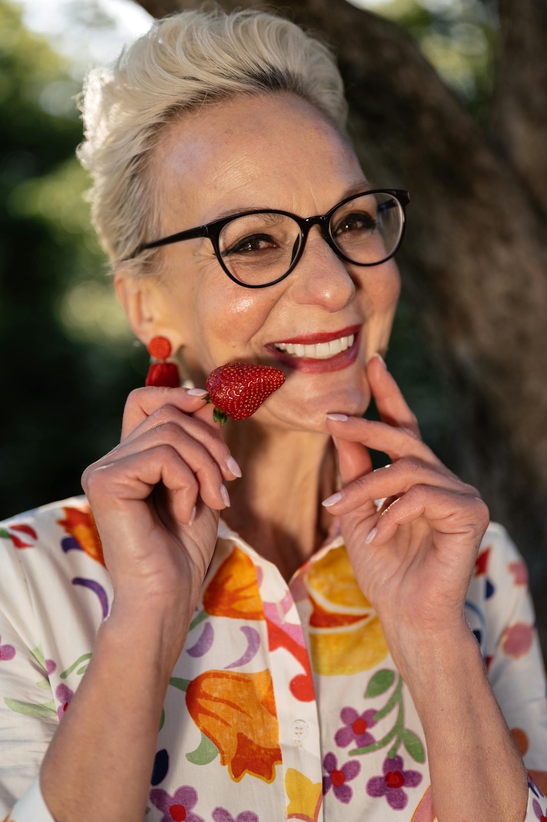 Une femme âgée tenant une fraise | Source : Pexels