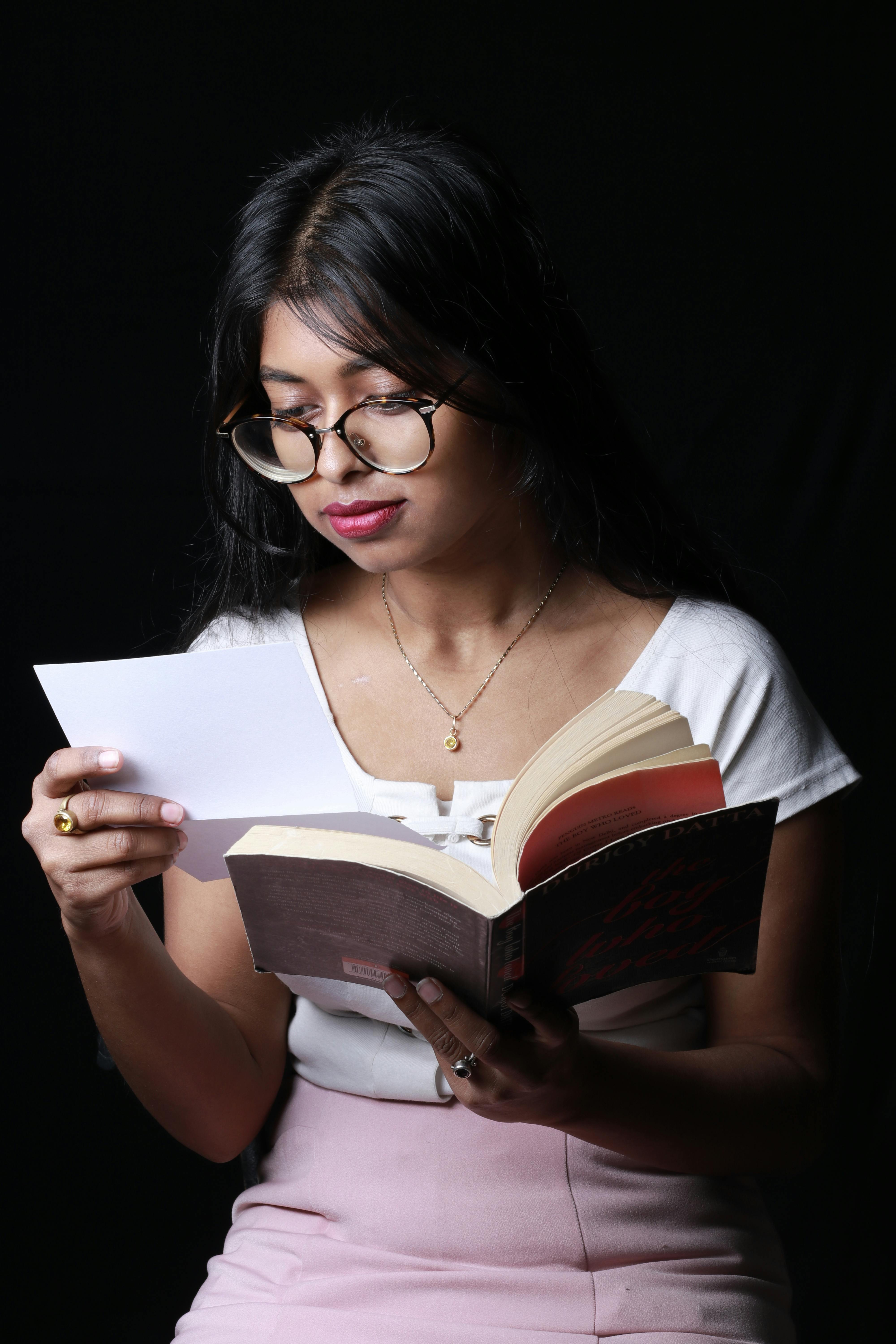 Une jeune fille lisant une lettre en tenant un livre | Source : Pexels