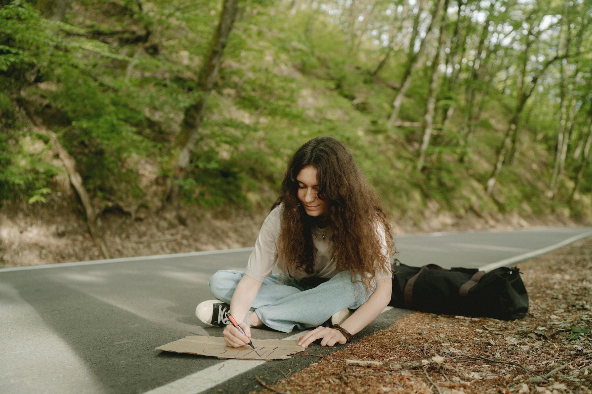 Une femme qui écrit sur un morceau de carton | Source : Pexels