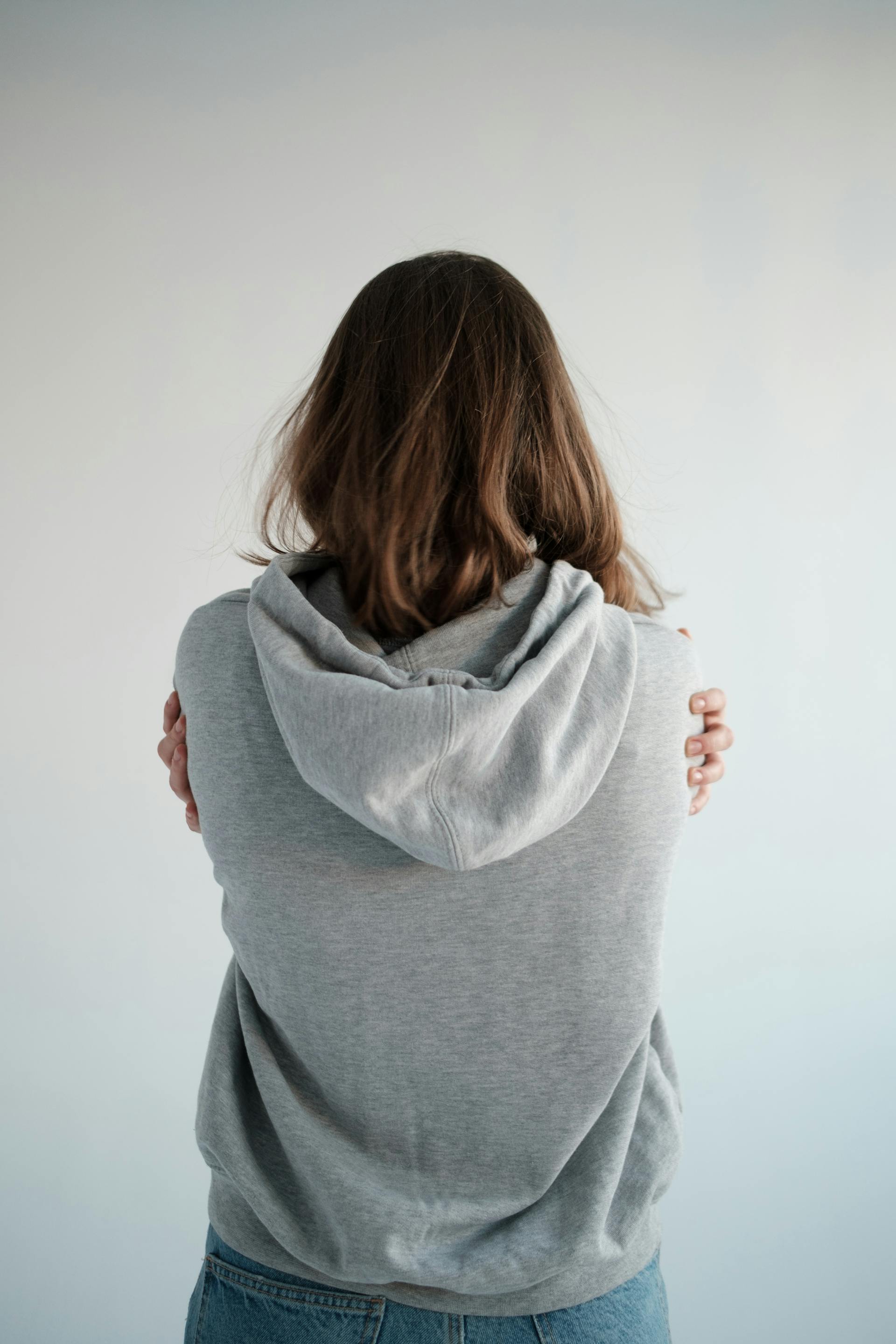 Jeune femme en sweat à capuche le dos tourné à la caméra | Source : Pexels