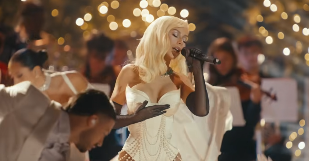 Lors de la même prestation, Christina Aguilera semble beaucoup plus mince grâce à un corset en satin ivoire qui souligne parfaitement ses courbes. | Source : Youtube/Christina Aguilera