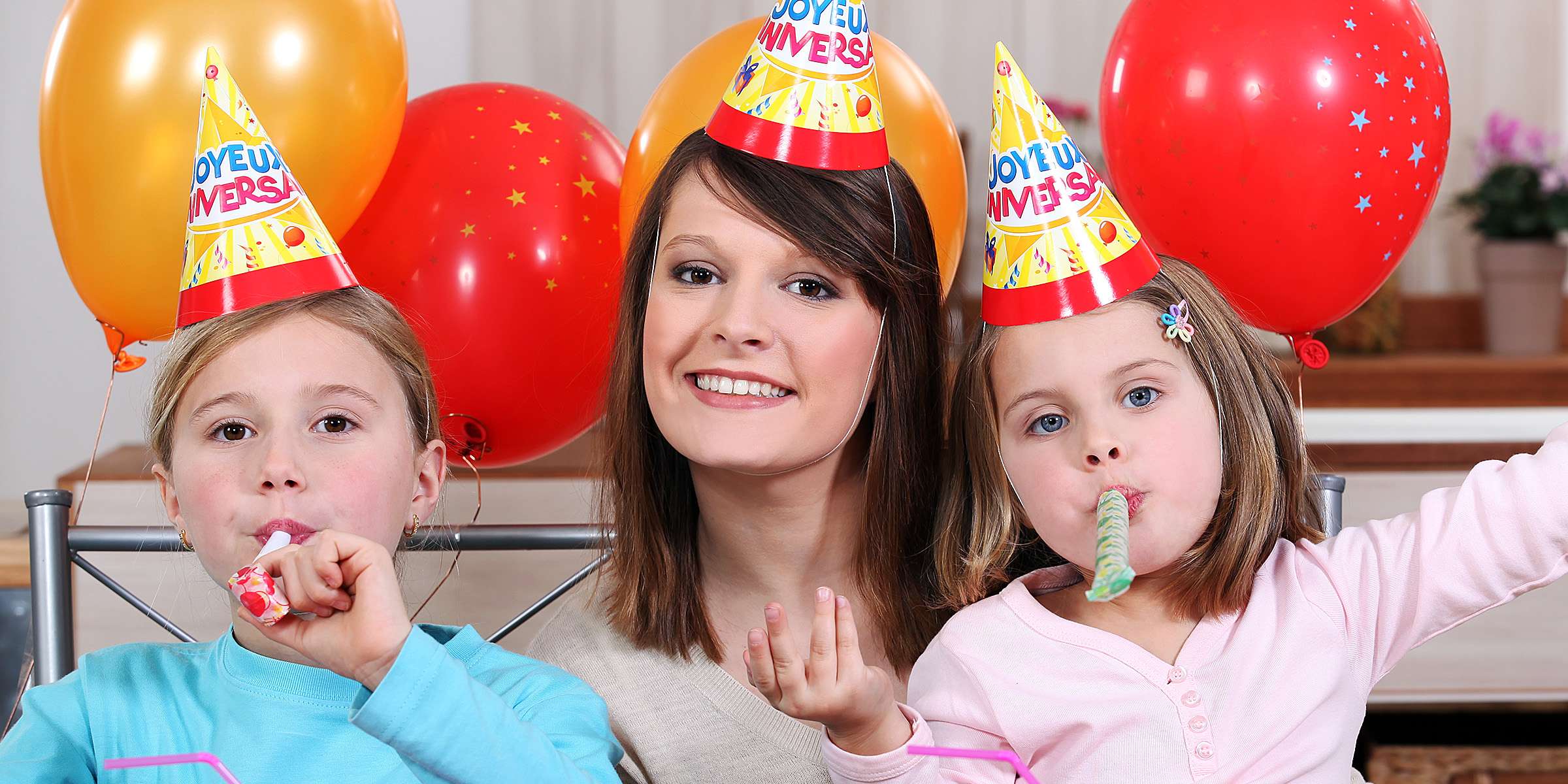 Une femme avec deux enfants lors d'une fête d'anniversaire | Source : Shutterstock