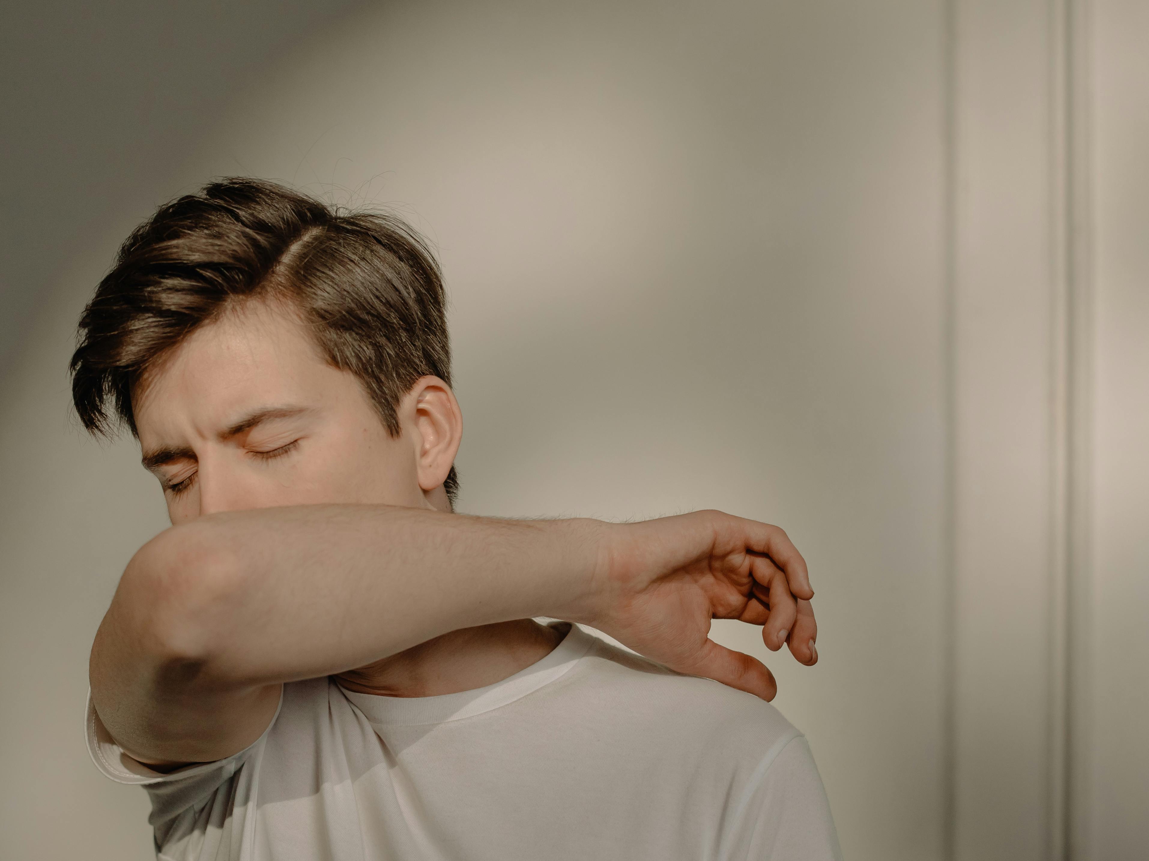 Un homme se couvrant la bouche en toussant | Source : Pexels