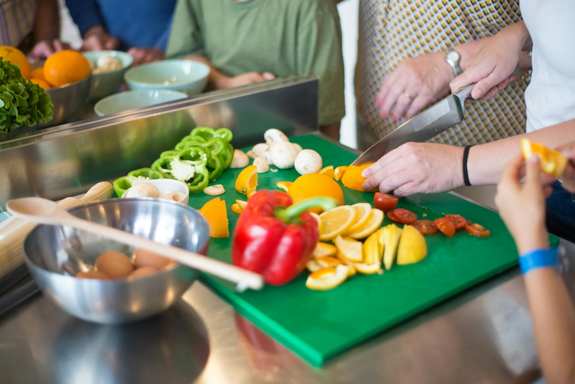 Gros plan sur les membres d'une famille en train de préparer des aliments dans la cuisine | Source : Pexels