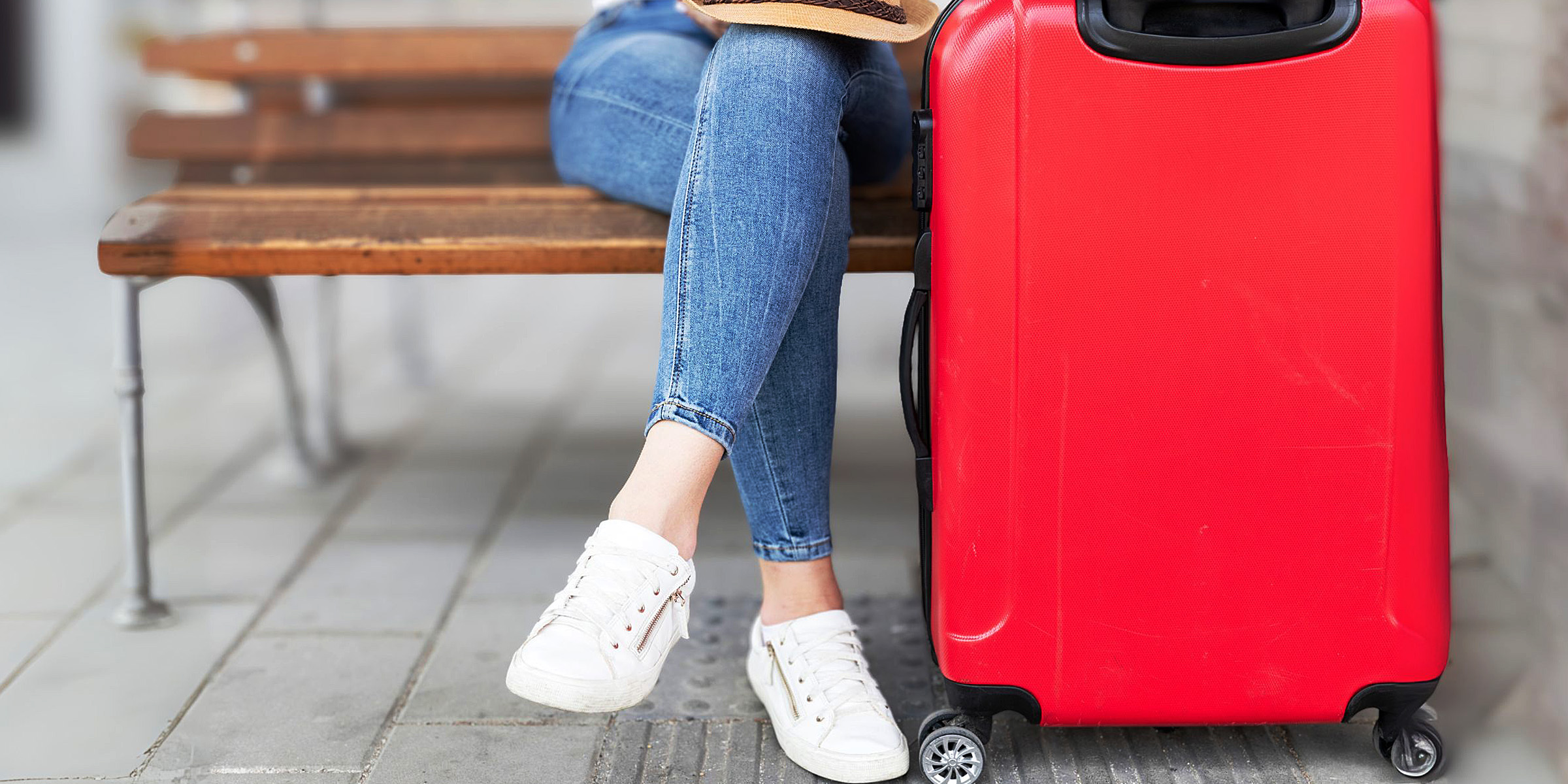 Une personne assise à côté d'une valise rouge | Source : Freepik