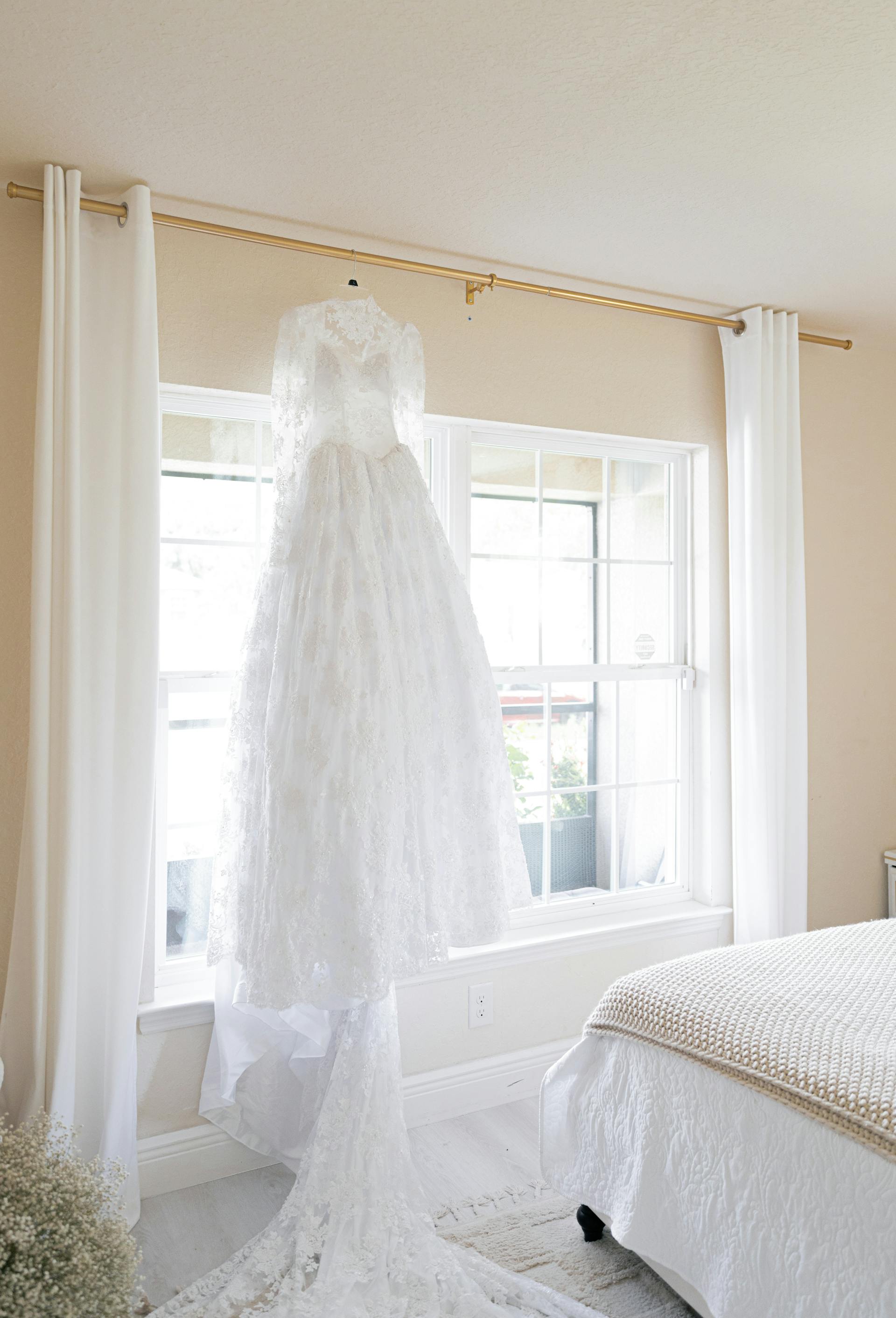 Une robe de mariée suspendue près d'une fenêtre | Source : Pexels