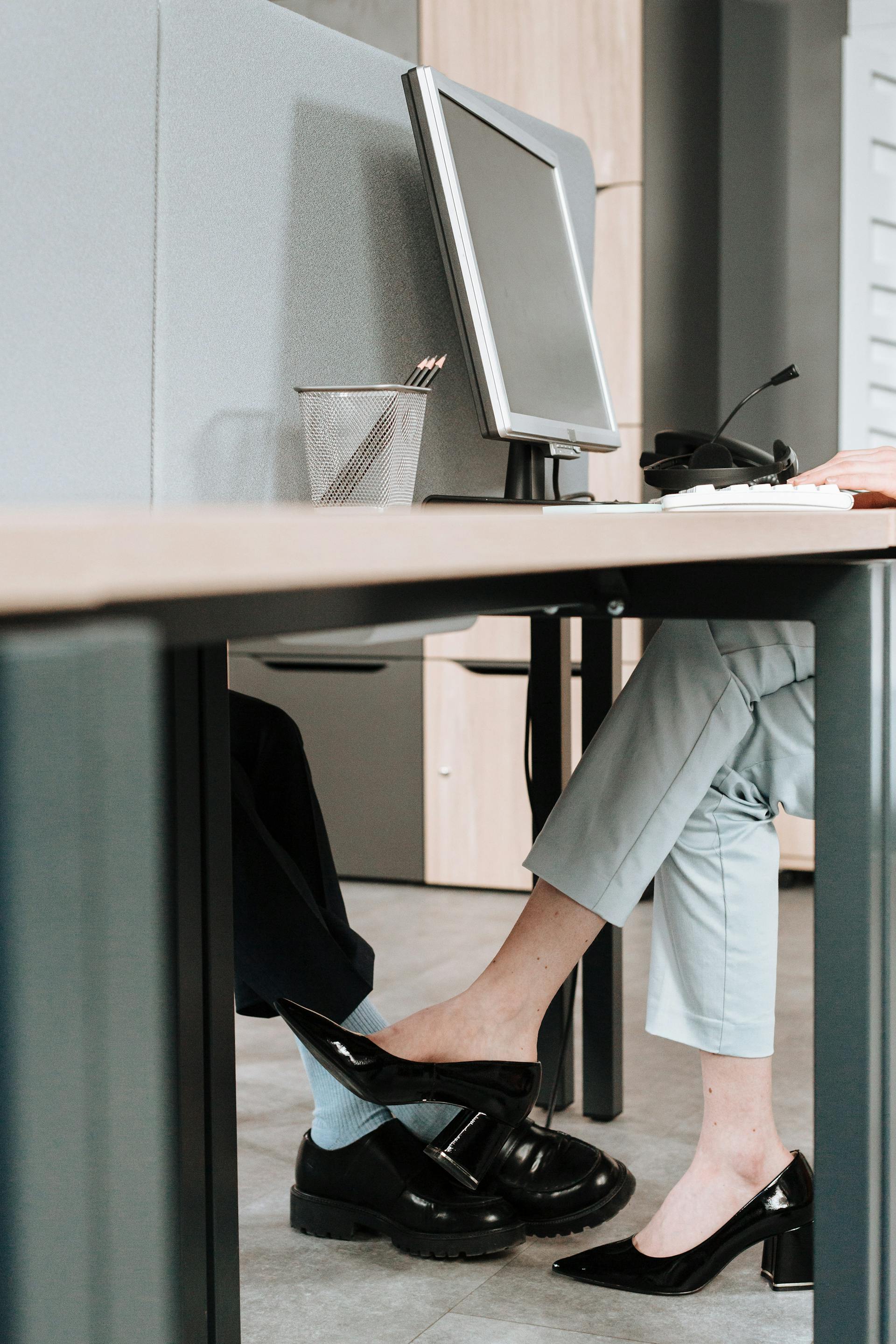 Des collègues qui flirtent sous le bureau | Source : Pexels