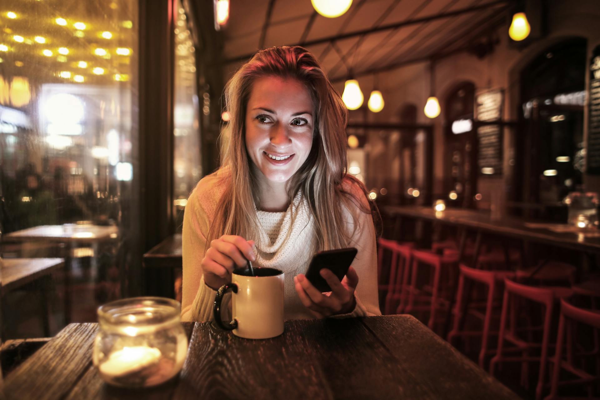 Une femme souriante assise dans un restaurant | Source : Pexels