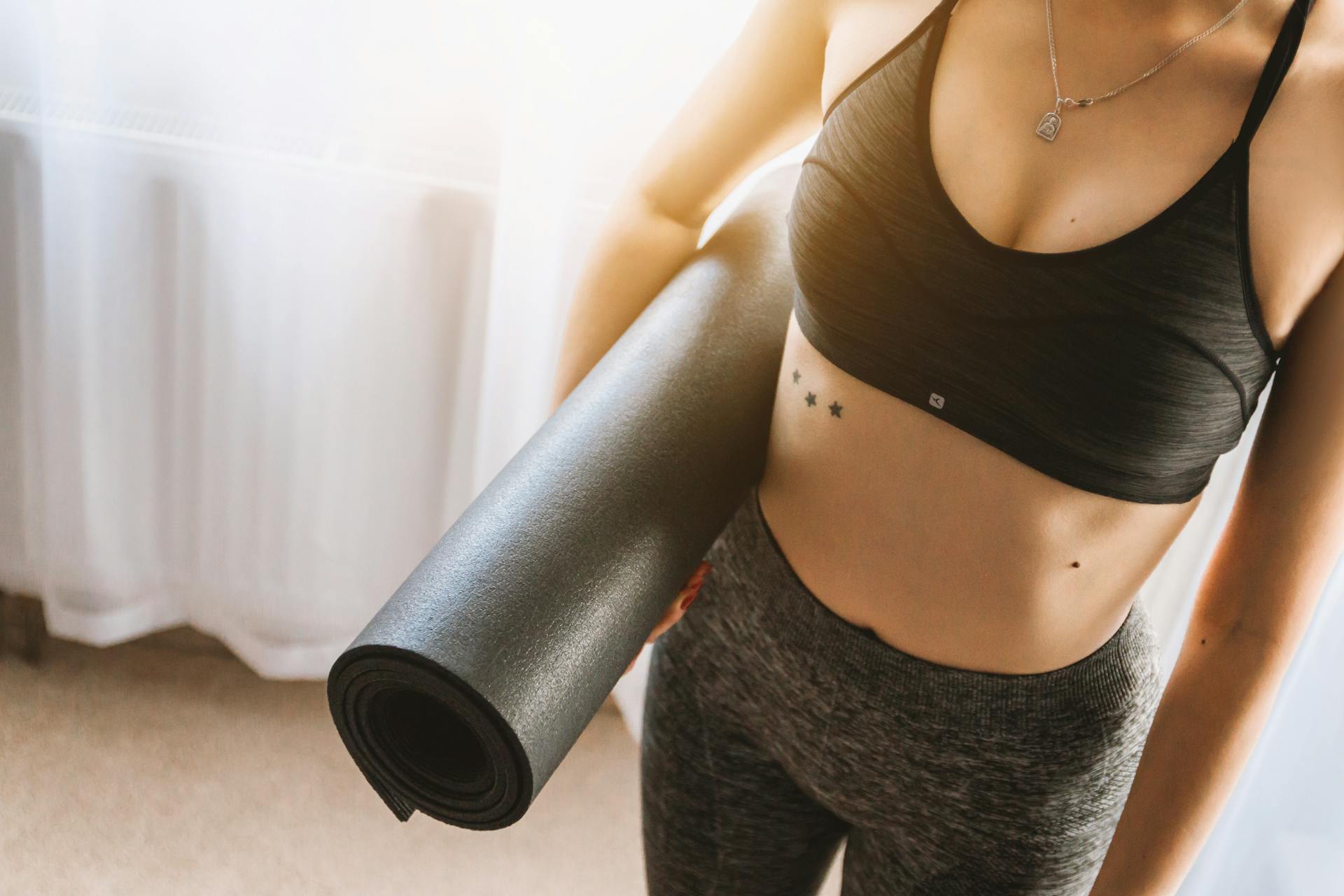 Une femme tenant un tapis de yoga | Source : Pexels