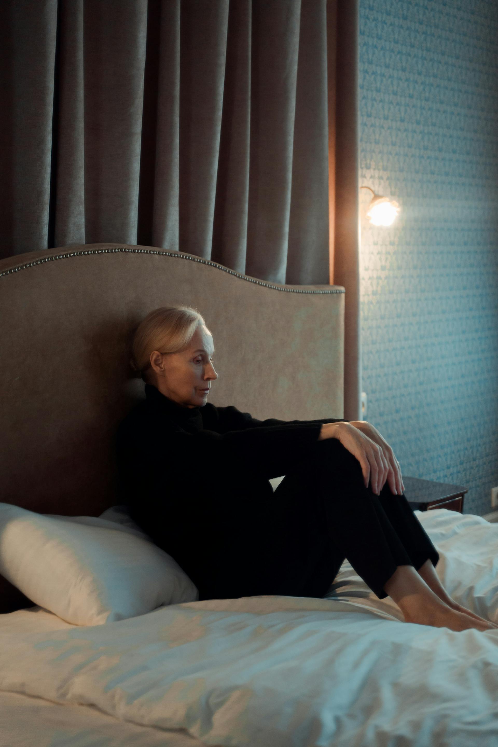 Une femme assise sur son lit | Source : Pexels