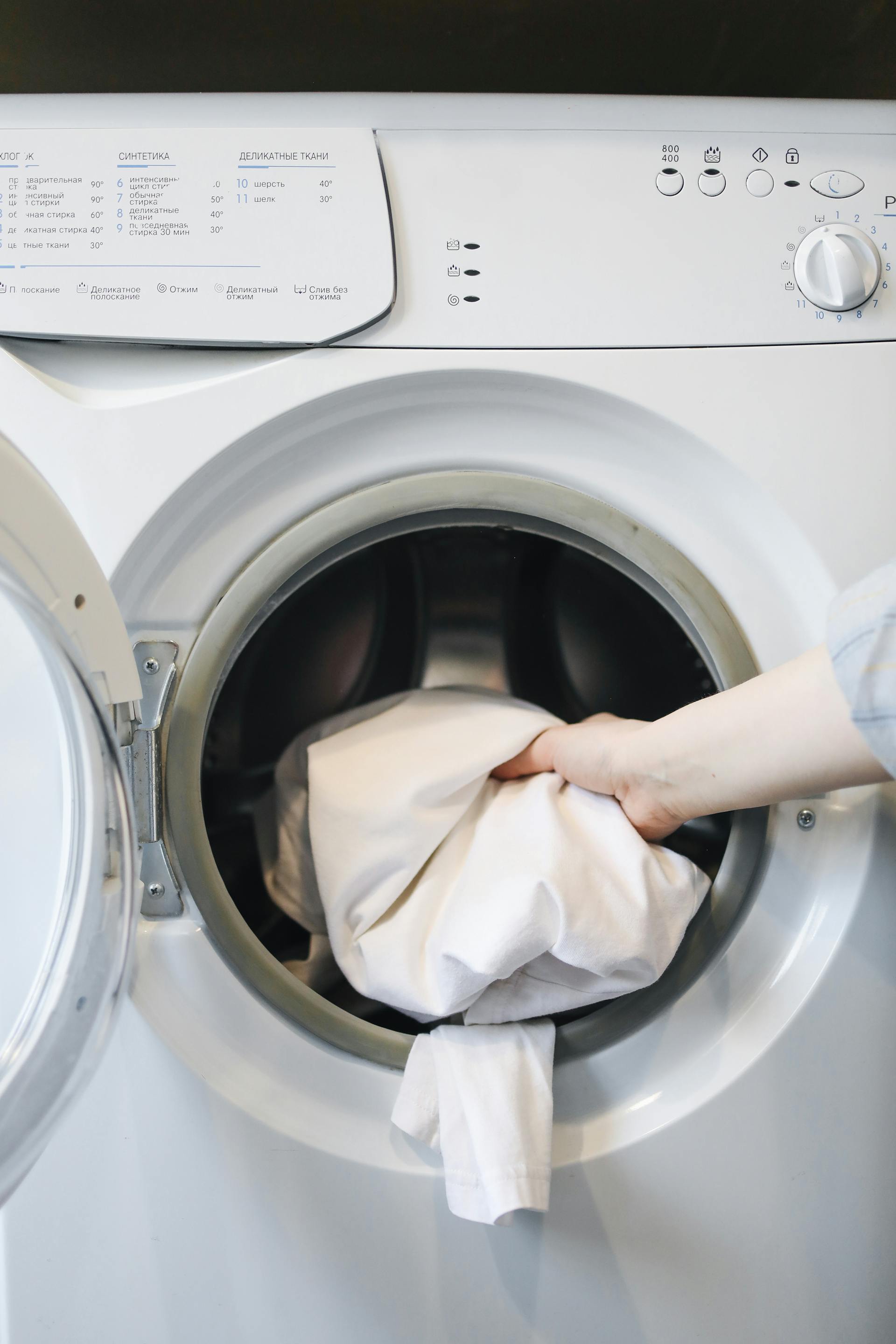 Une personne mettant des vêtements dans une machine à laver | Source : Pexels