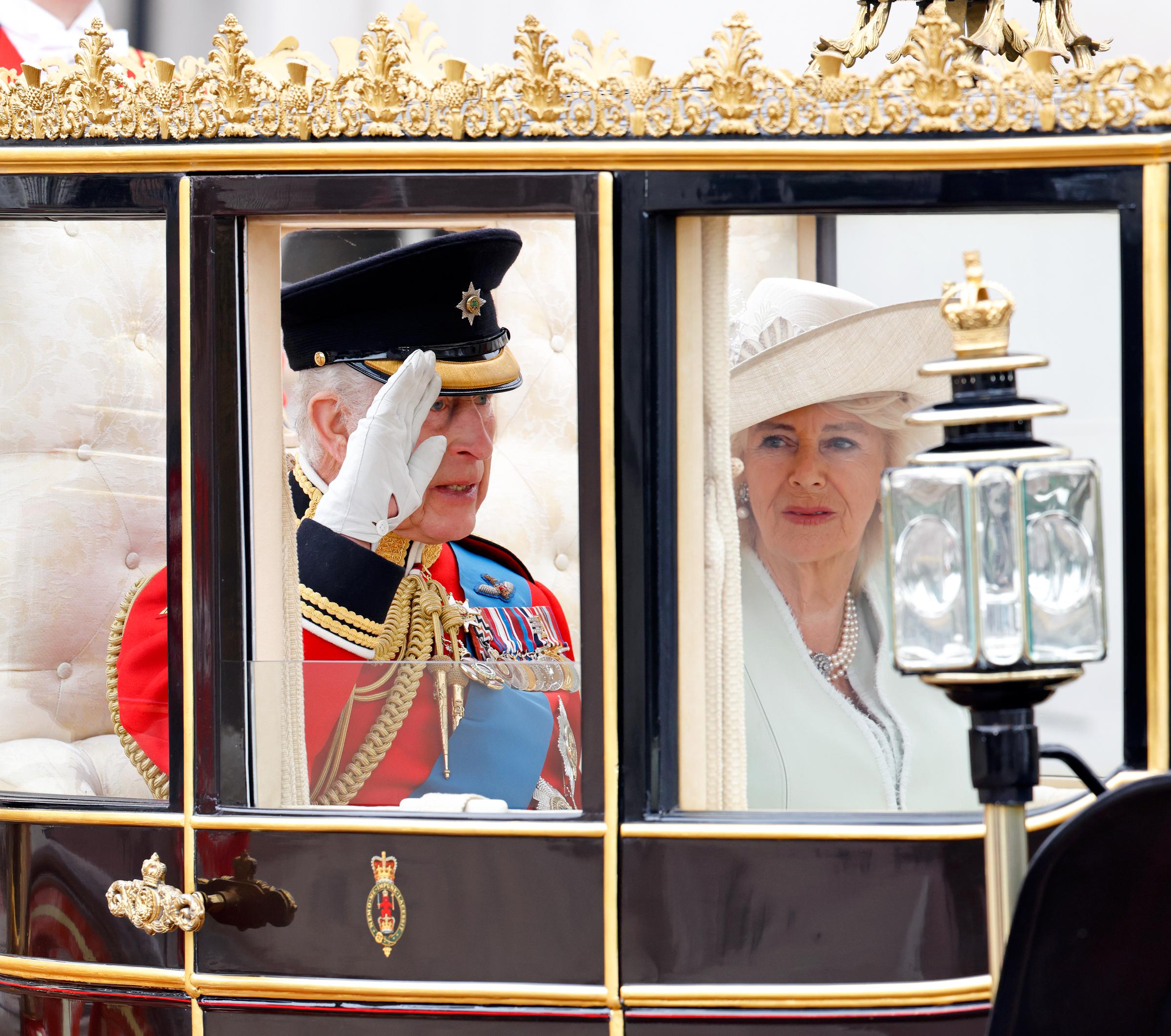 Le roi Charles III salue dans le carrosse de l'État écossais aux côtés de la reine Camilla alors qu'ils quittent le palais de Buckingham en direction de Horse Guards Parade, le 15 juin 2024 | Source : Getty Images
