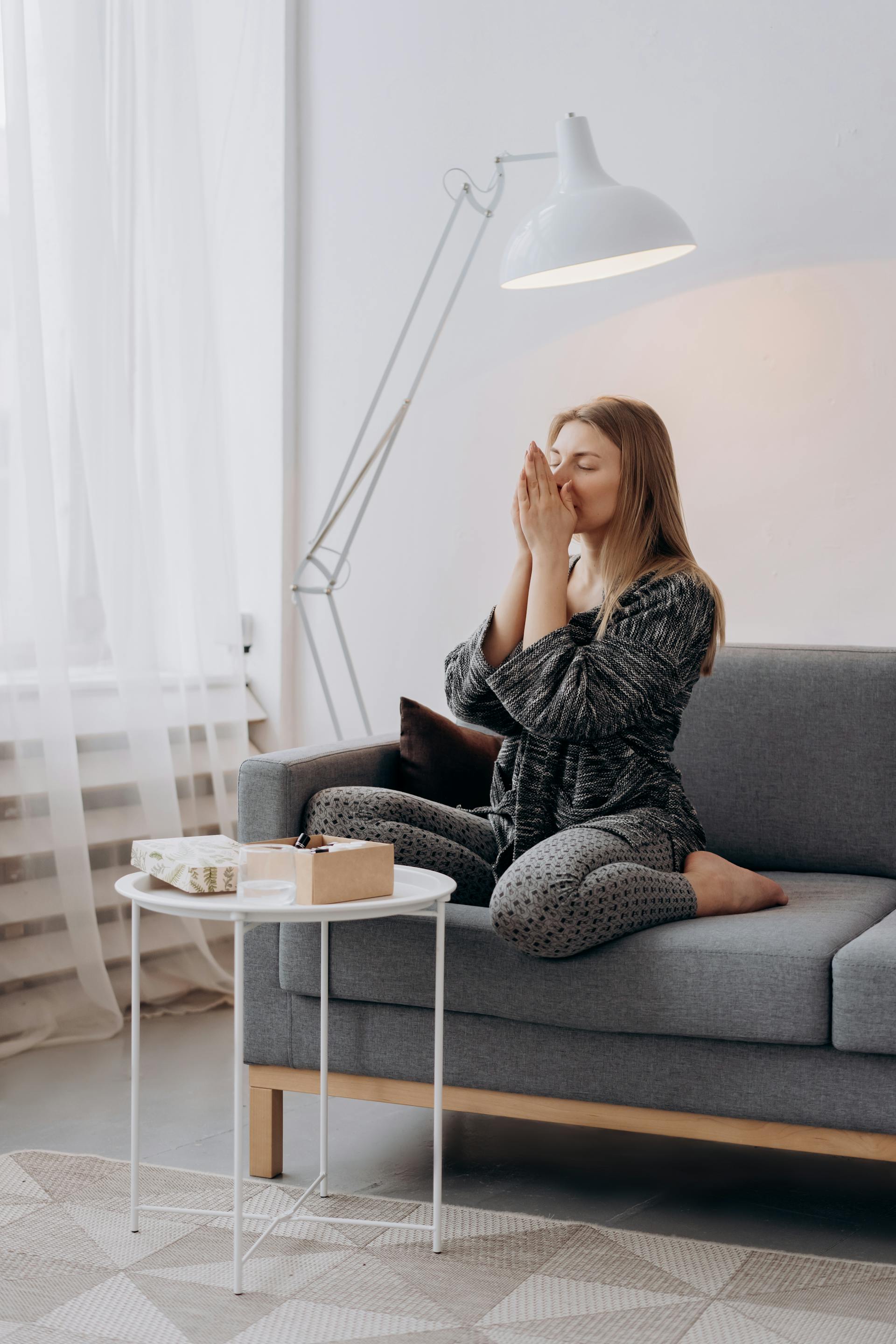 Une femme fatiguée assise sur le canapé | Source : Pexels