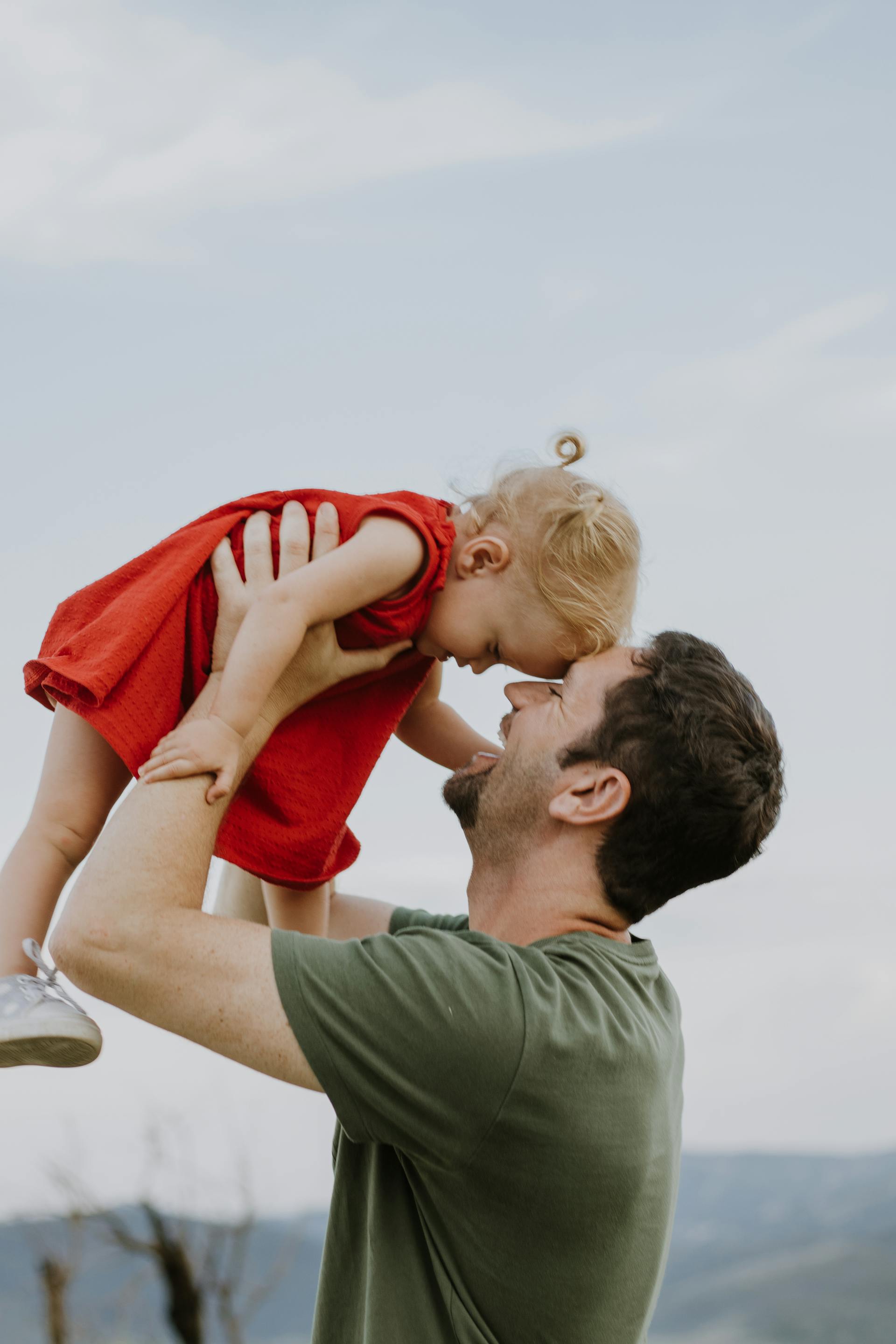 Un homme heureux tenant une petite fille dans ses bras | Source : Pexels