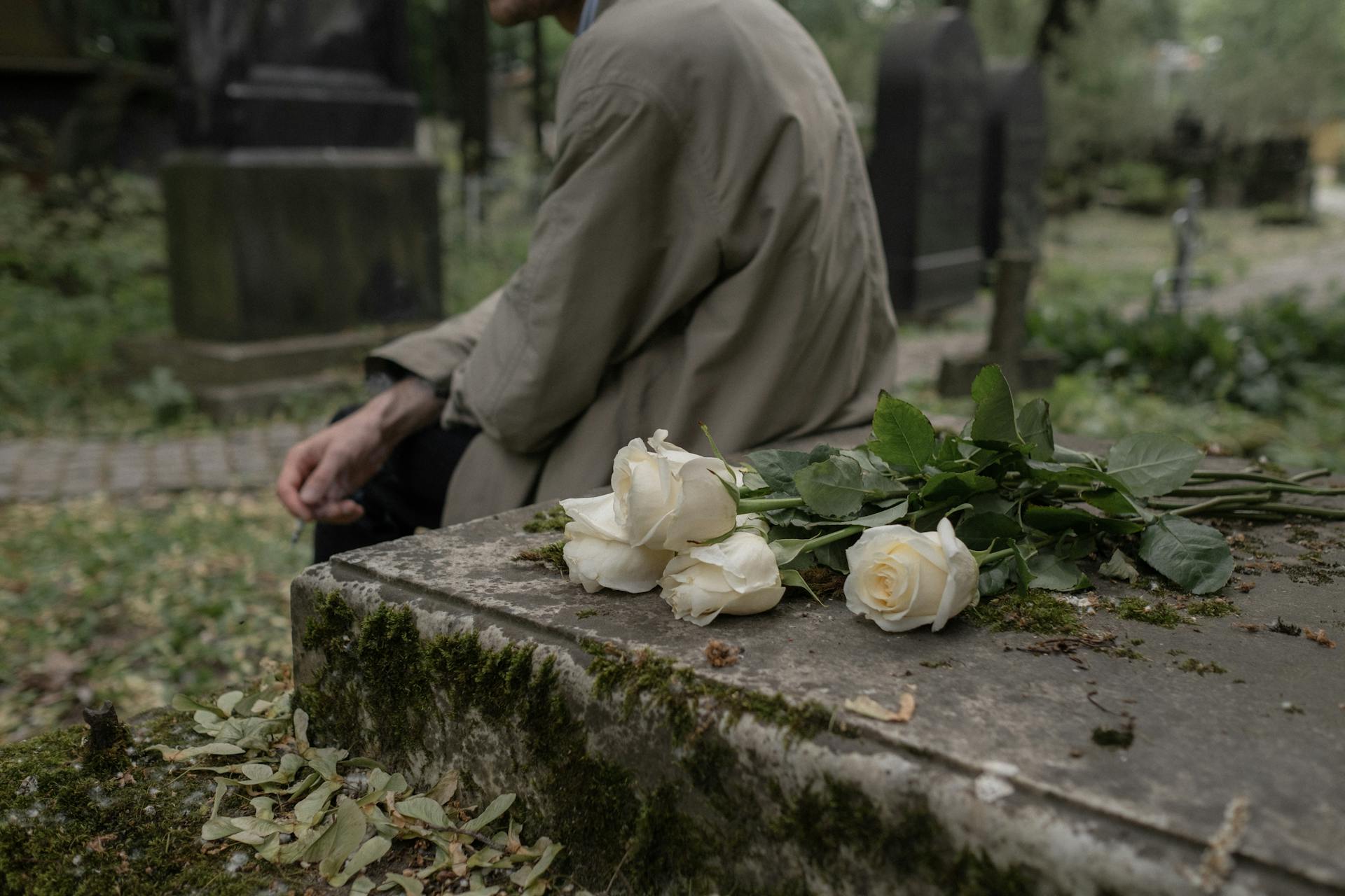 Une personne assise près d'une tombe | Source : Pexels