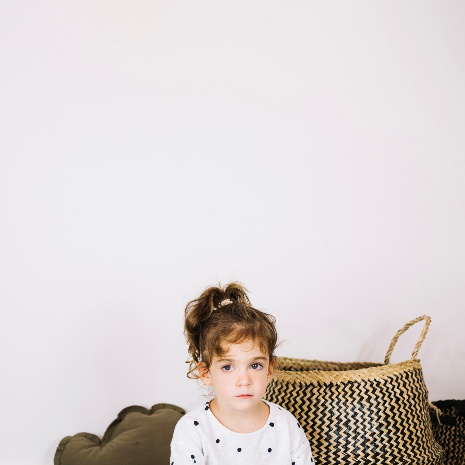 Une petite fille triste assise près d'un panier | Source : Freepik