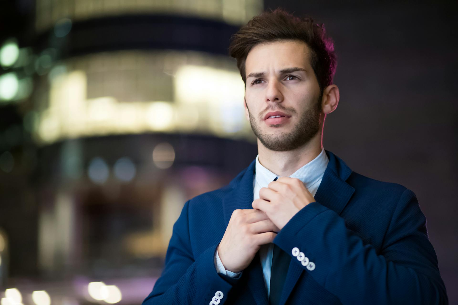 Un bel homme qui ajuste sa cravate | Source : Pexels