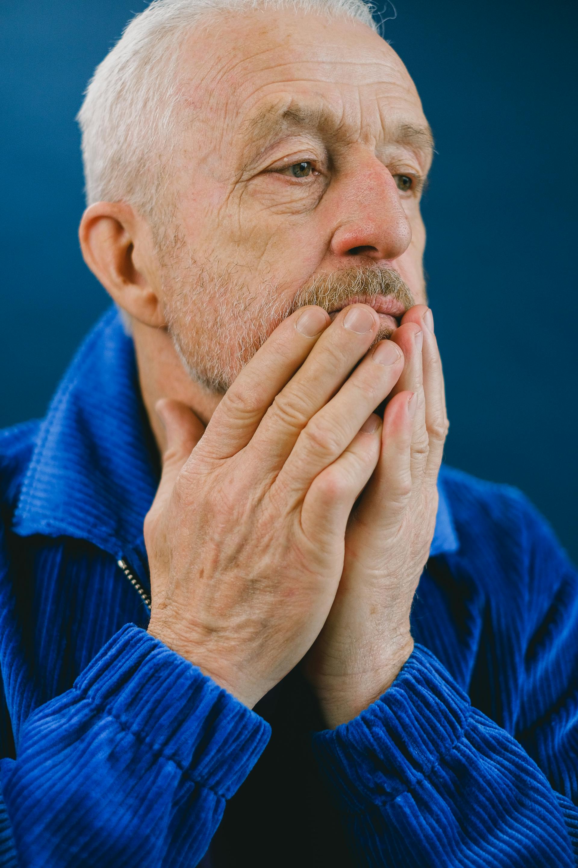 Un homme âgé debout, les mains sur le visage | Source : Pexels