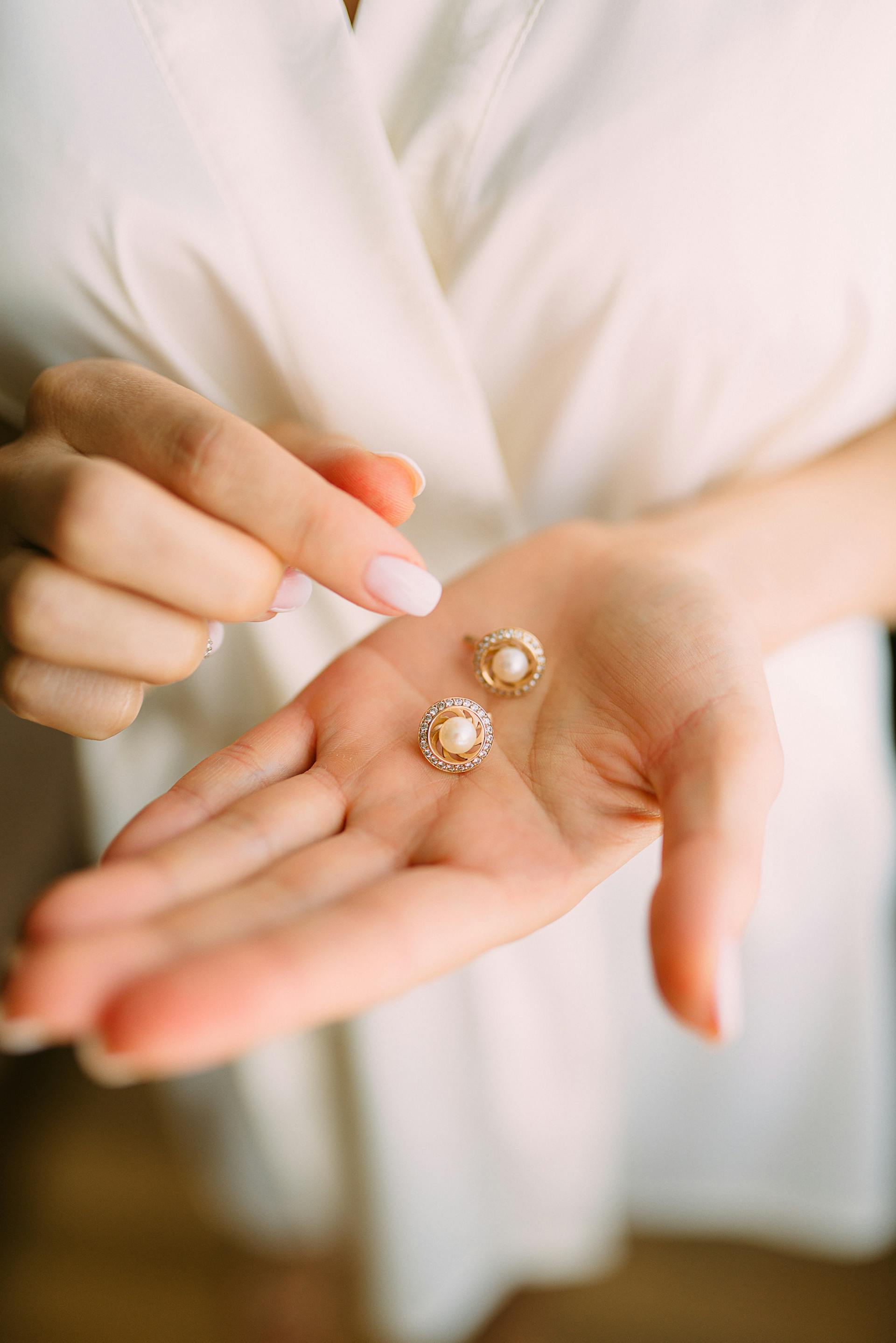 Une personne tenant des boucles d'oreilles | Source : Pexels