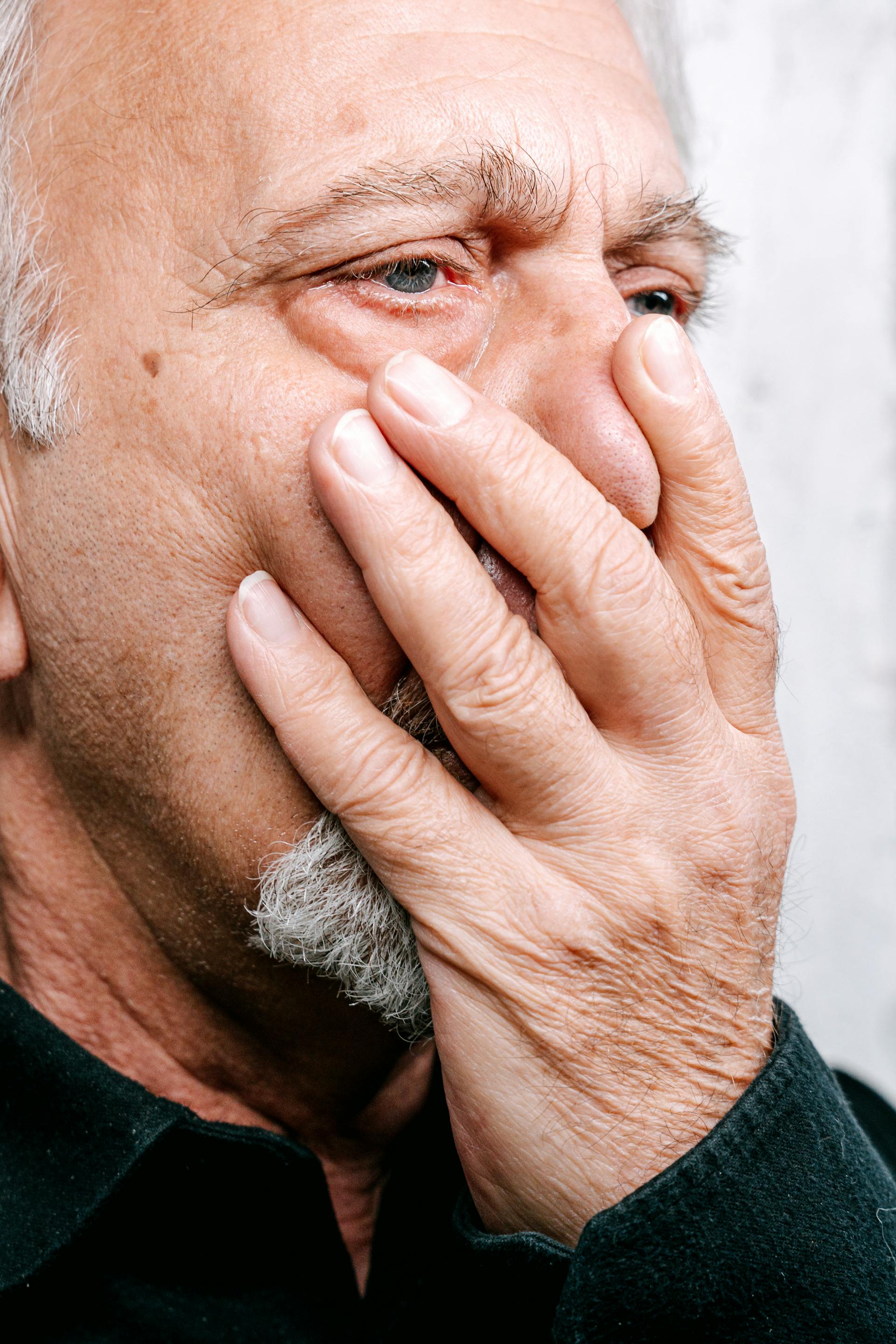 Un homme se couvrant la bouche d'une main | Source : Pexels
