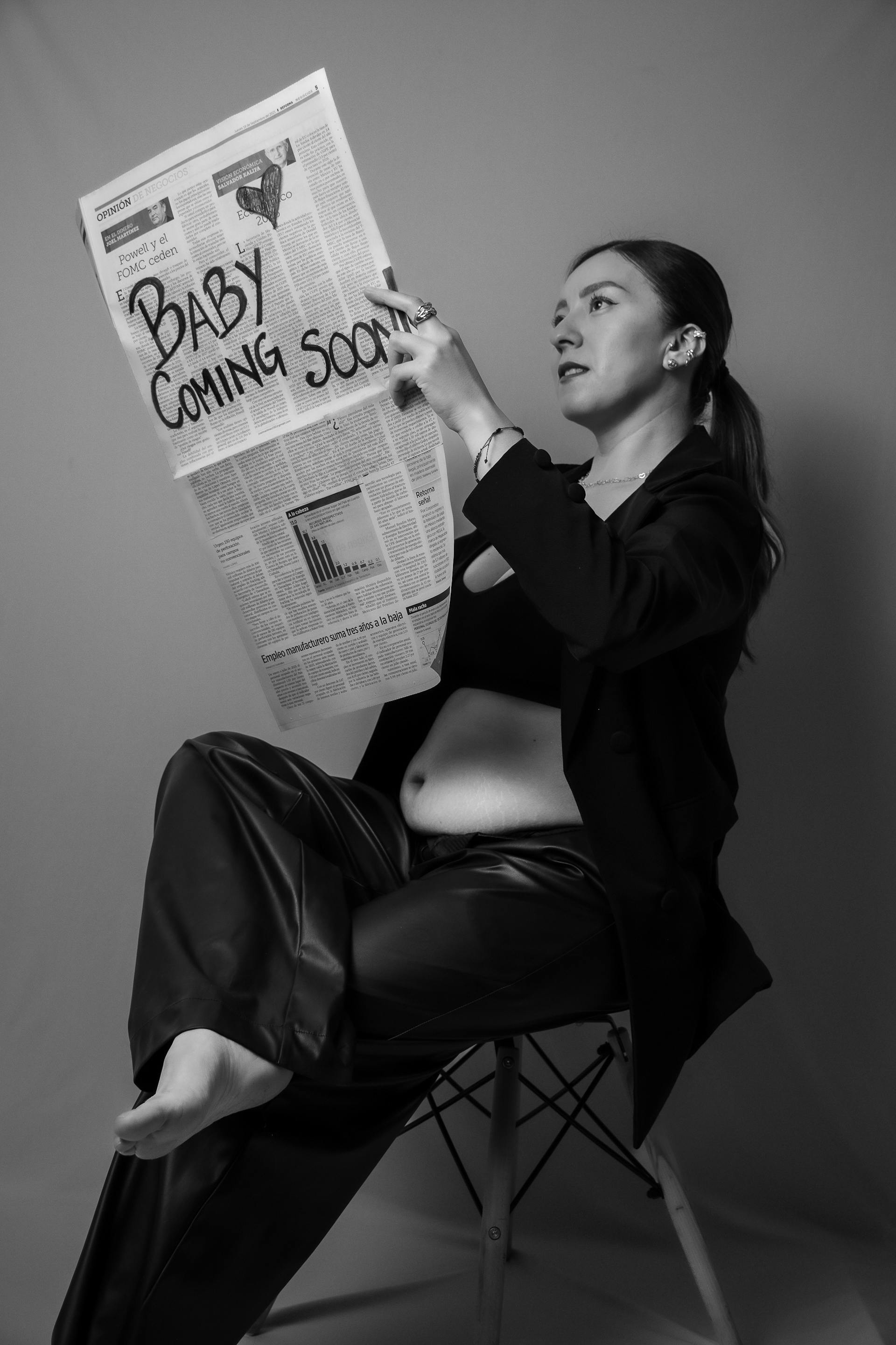 Photo en niveaux de gris d'une femme enceinte tenant un journal | Source : Pexels