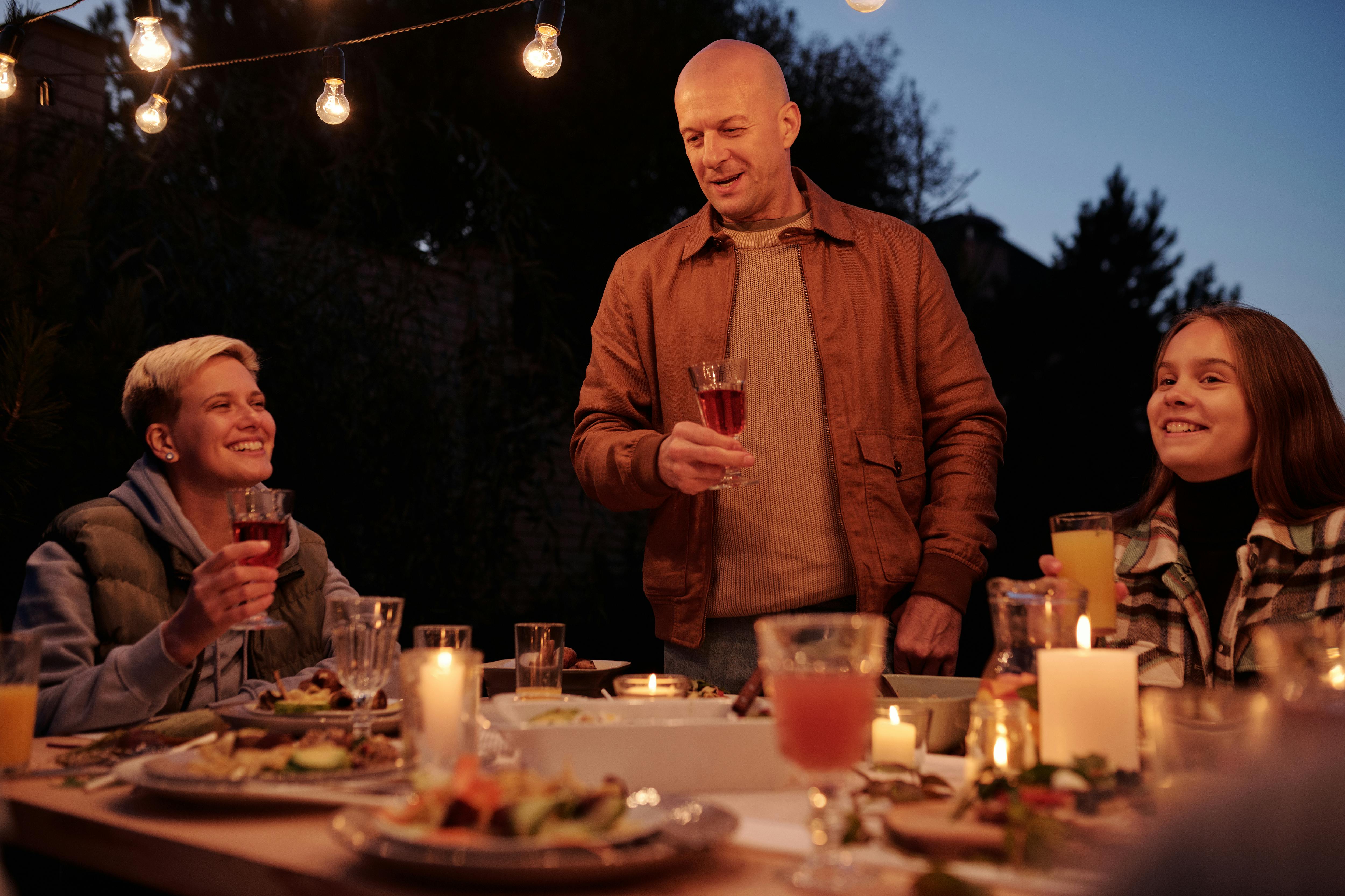 Un homme portant un toast lors d'un dîner en famille | Source : Pexels