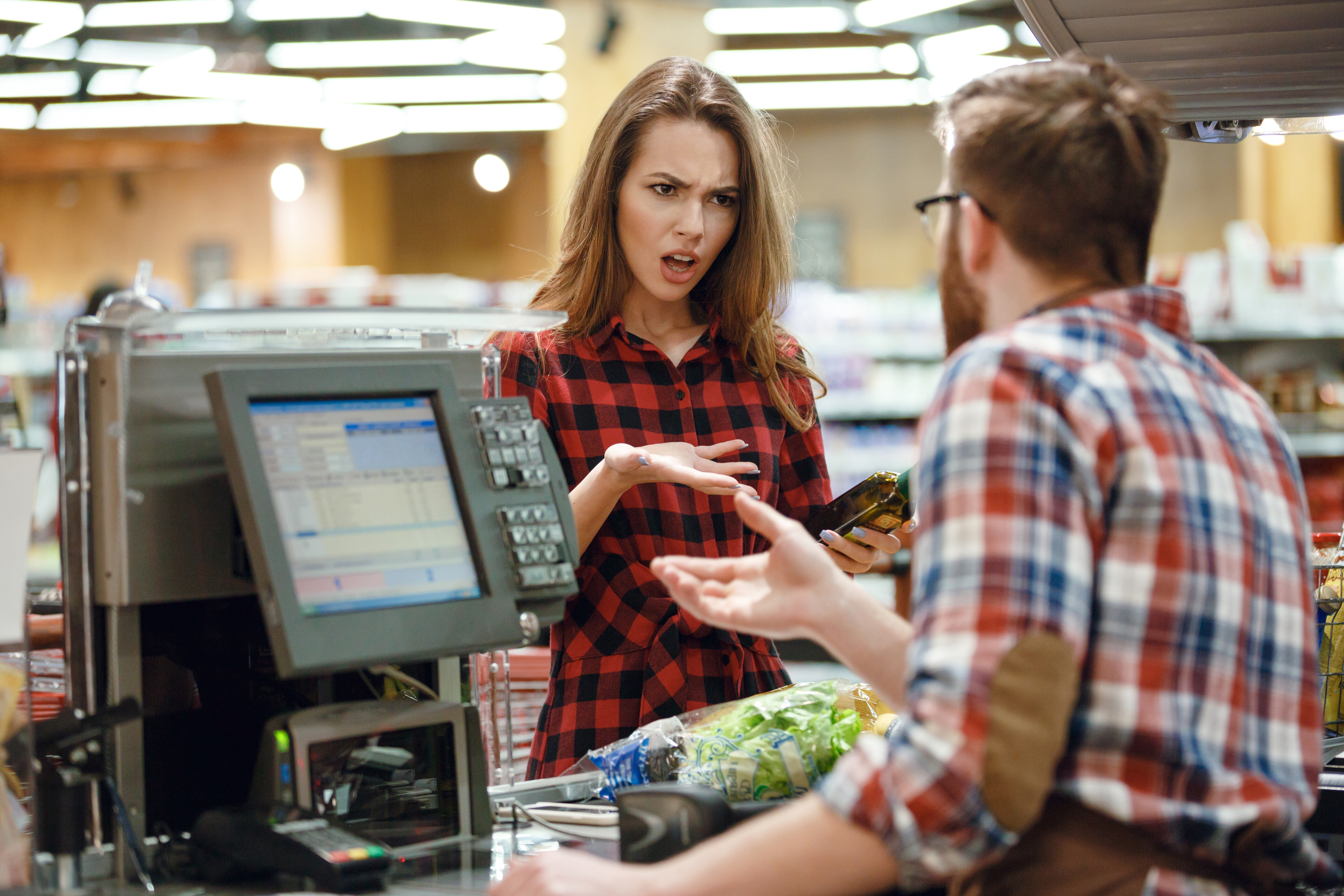 Une caissière en colère s'occupe d'un client | Source : Shutterstock