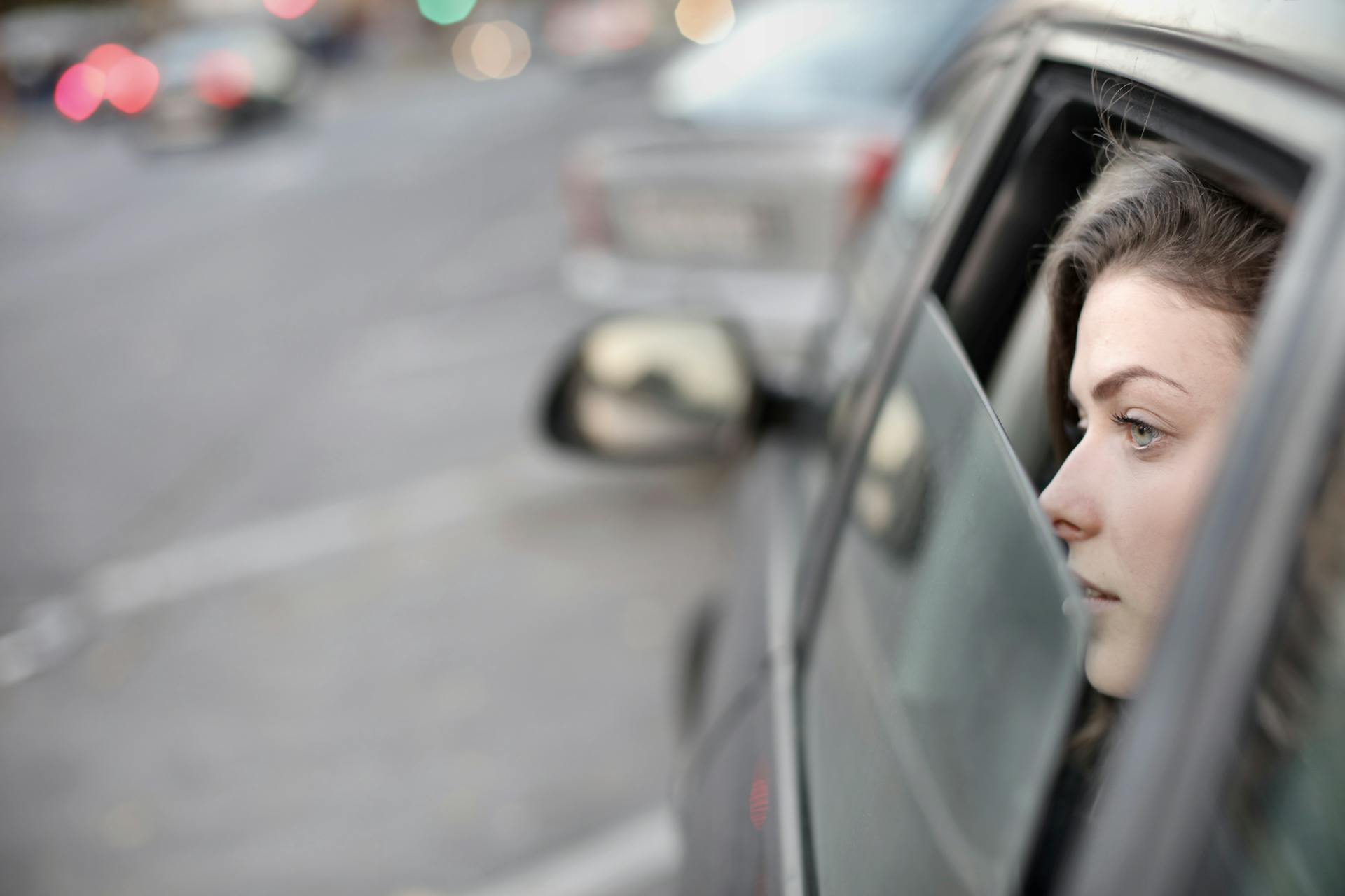 Une femme qui regarde par la fenêtre de la voiture | Source : Pexels