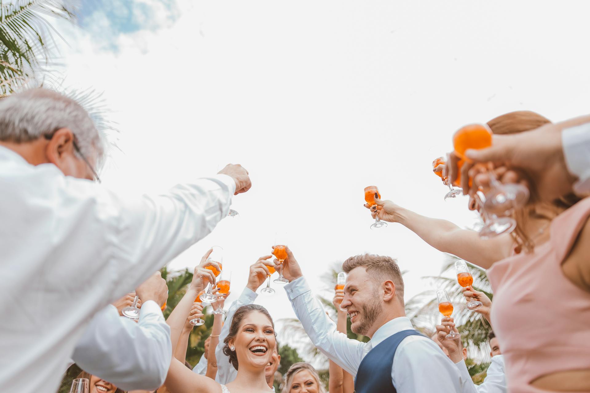 Des gens trinquent avec leurs boissons lors d'un mariage | Source : Pexels