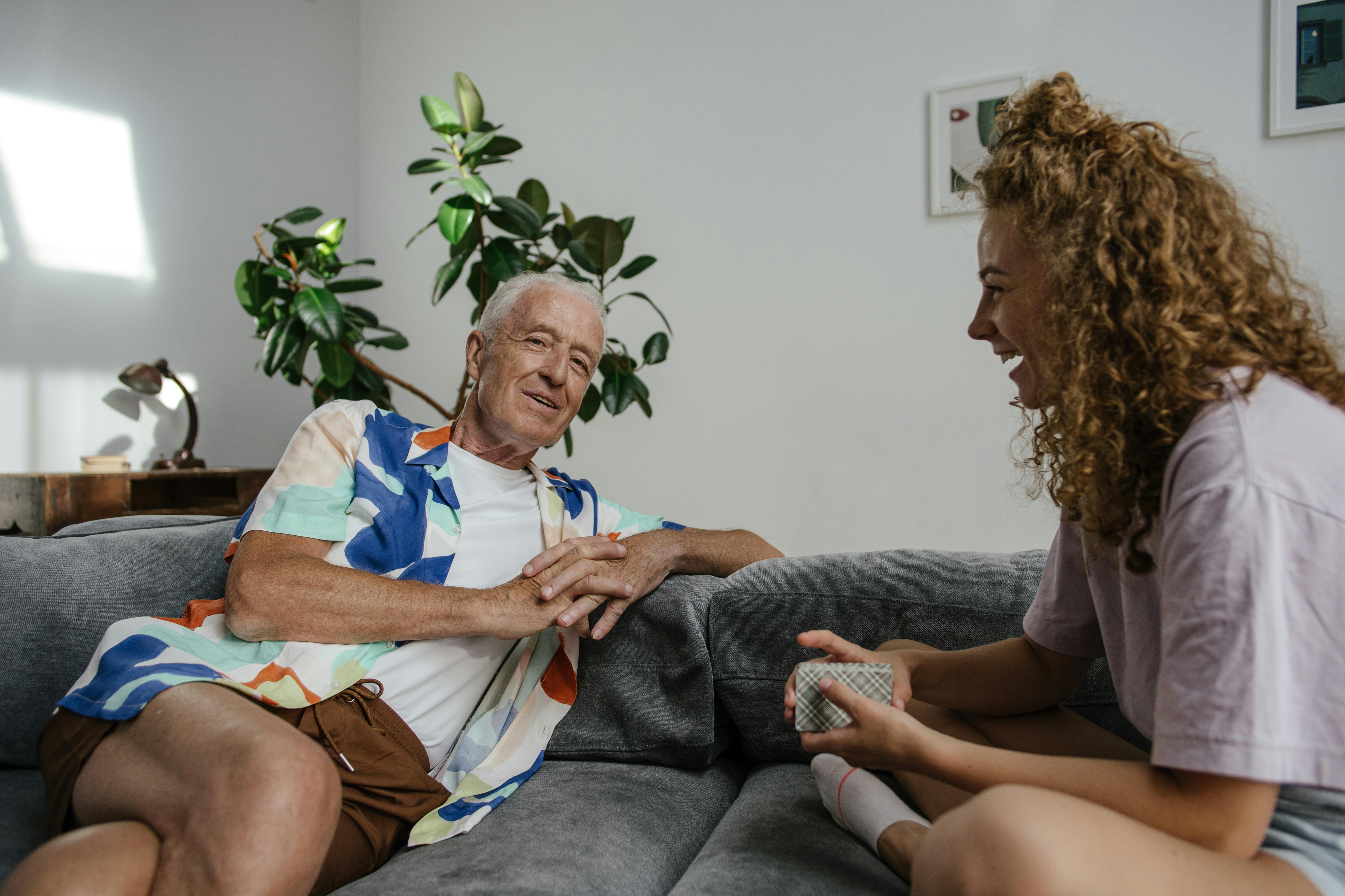 Un homme âgé souriant et une jeune femme en train de discuter | Source : Pexels