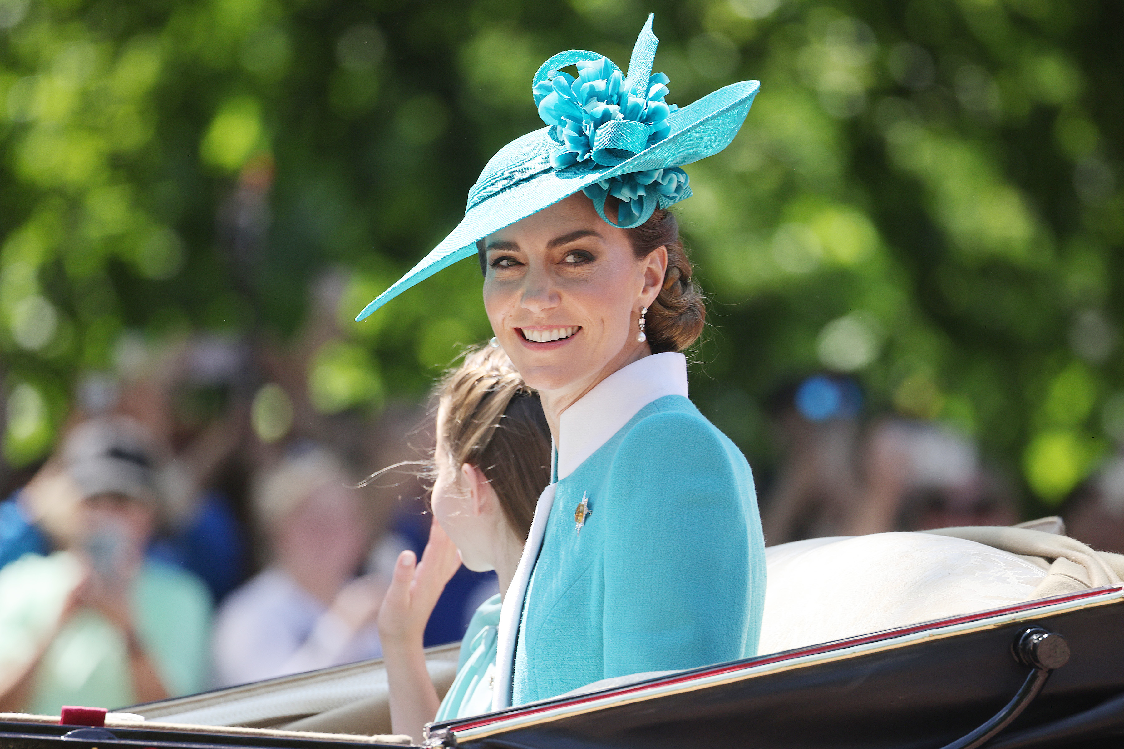 La princesse Catherine partage un sourire radieux avec la foule alors qu'elle se tient aux côtés de la princesse Charlotte lors du Trooping the Colour 2025 à Londres. Le duo mère-fille capture un moment de grâce et d'équilibre au milieu du spectacle royal, la chaleur posée de Catherine faisant écho à la foule qui l'acclame.
