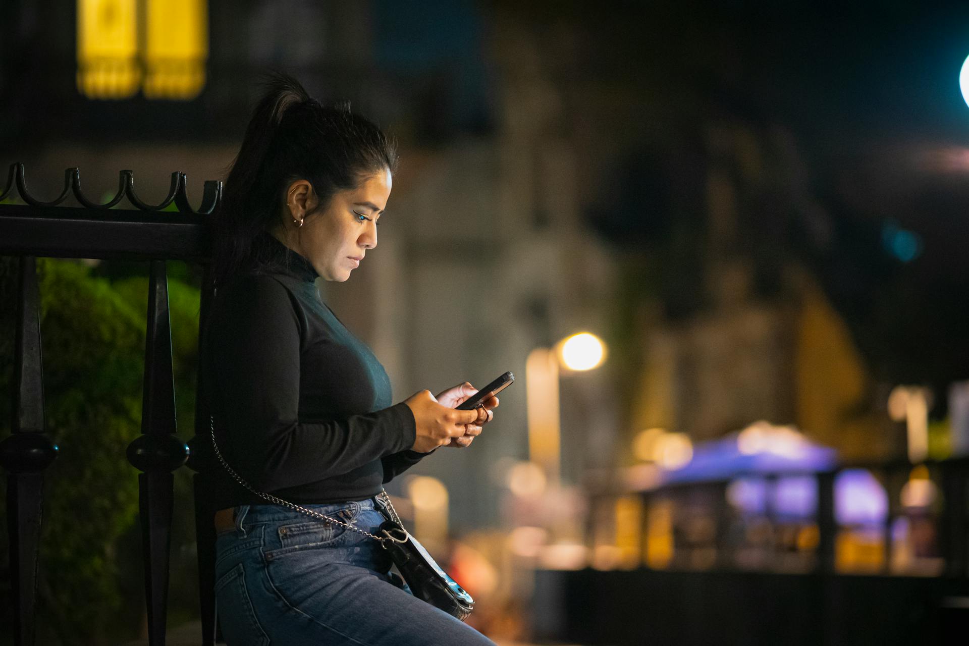 Une femme tenant un téléphone la nuit | Source : Pexels