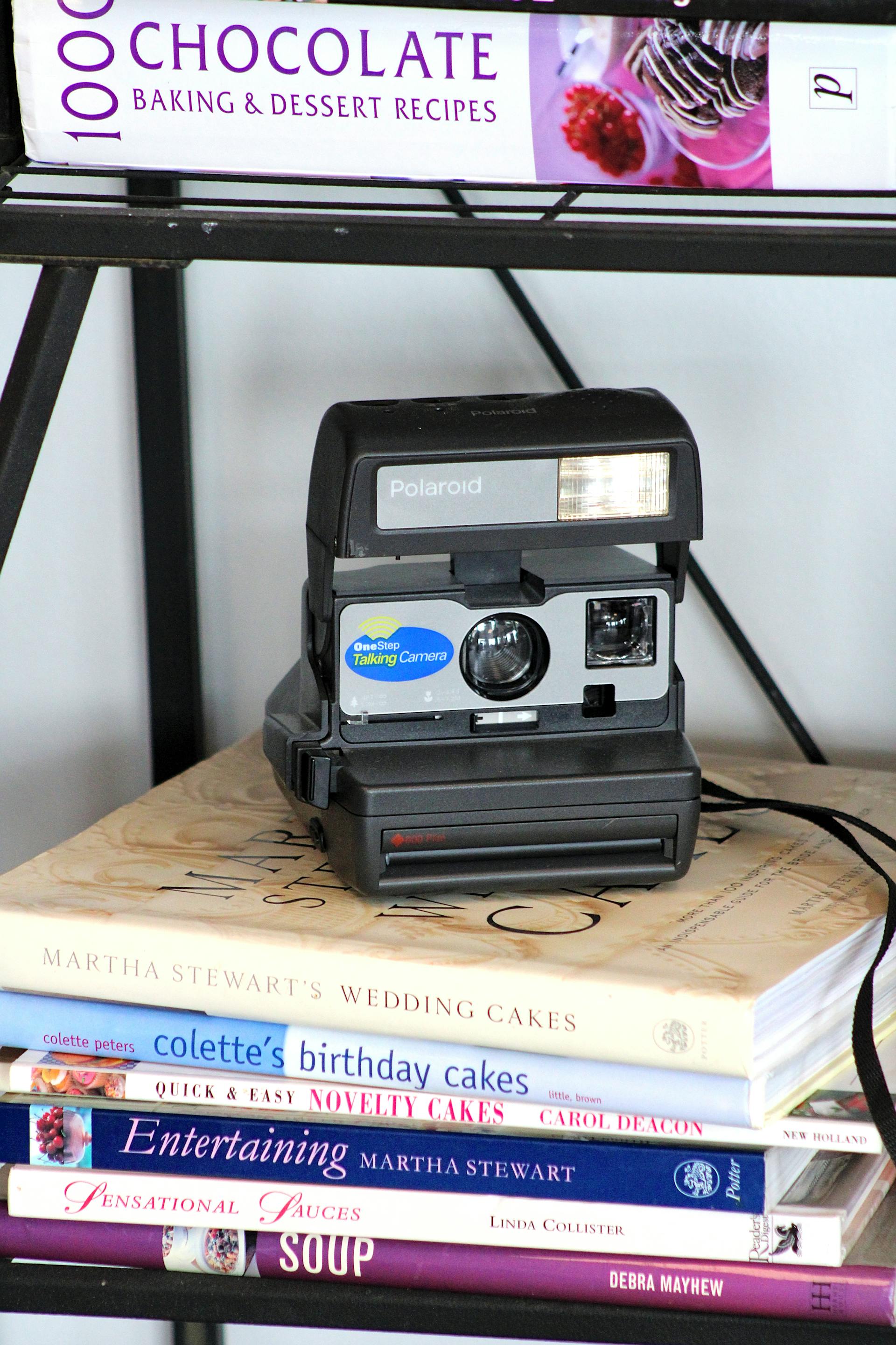 Un appareil photo polaroid vintage posé sur des livres de cuisine | Source : Pexels