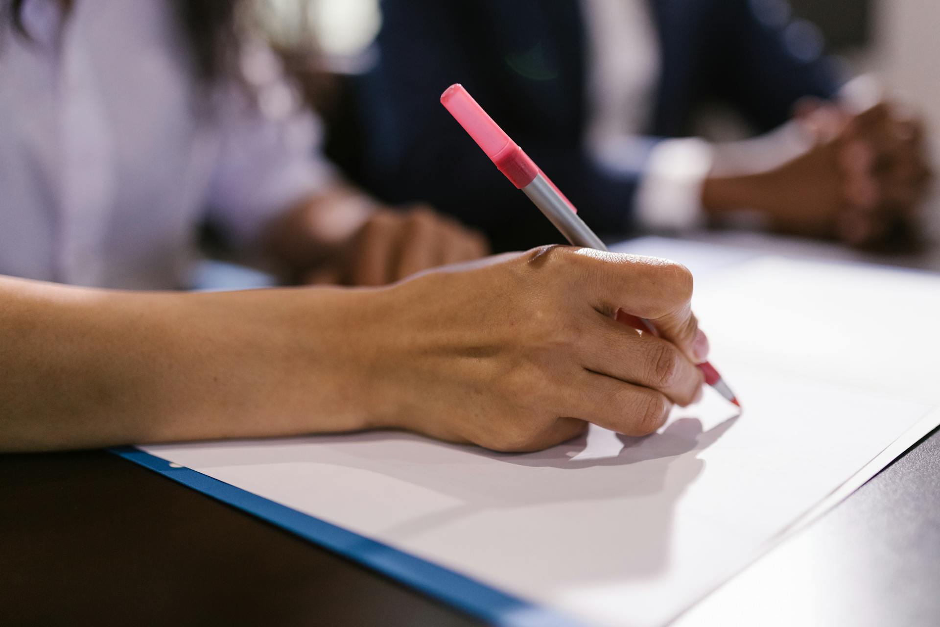 Une personne qui écrit sur un papier | Source : Pexels