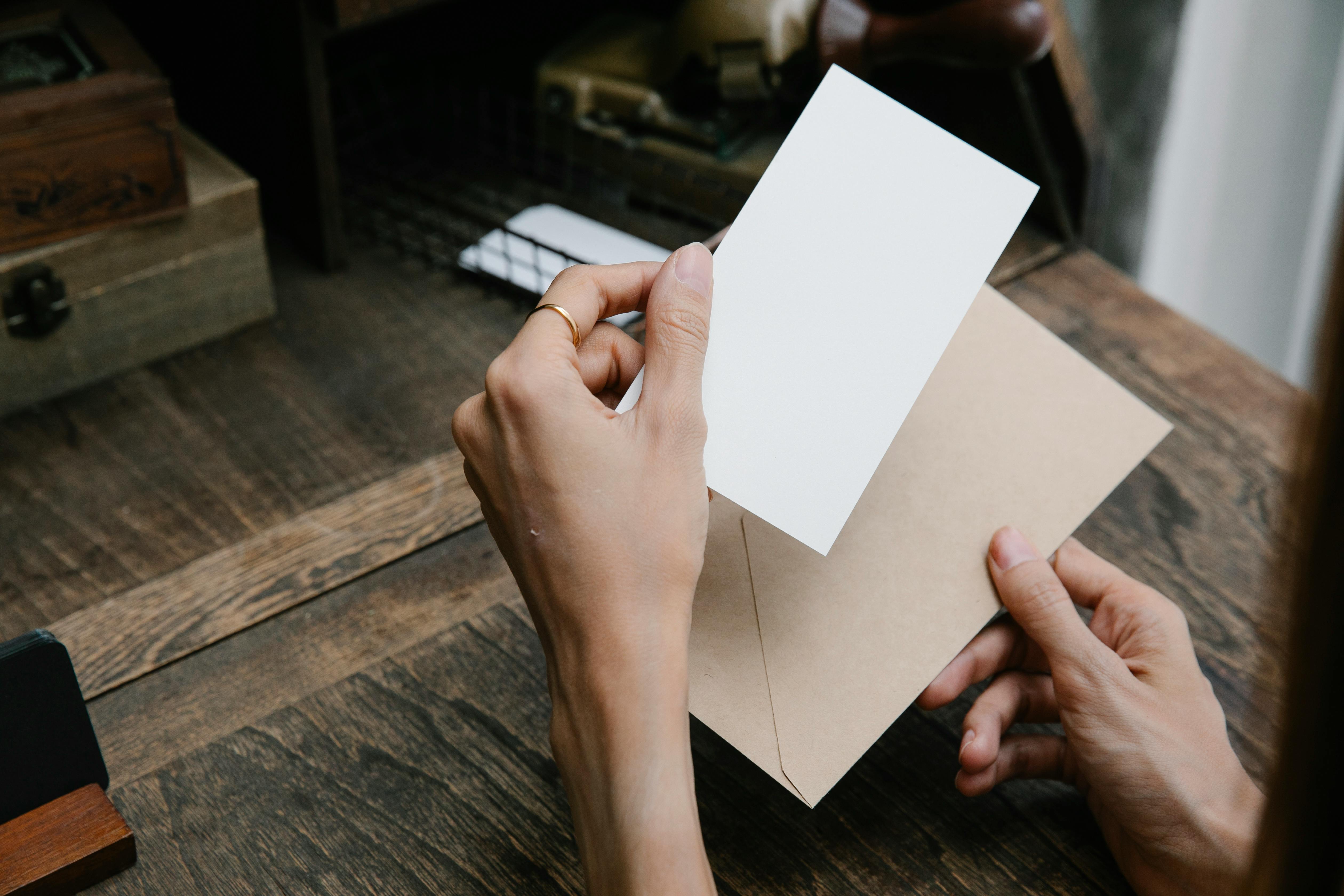 Une personne tenant un morceau de papier et une enveloppe | Source : Pexels