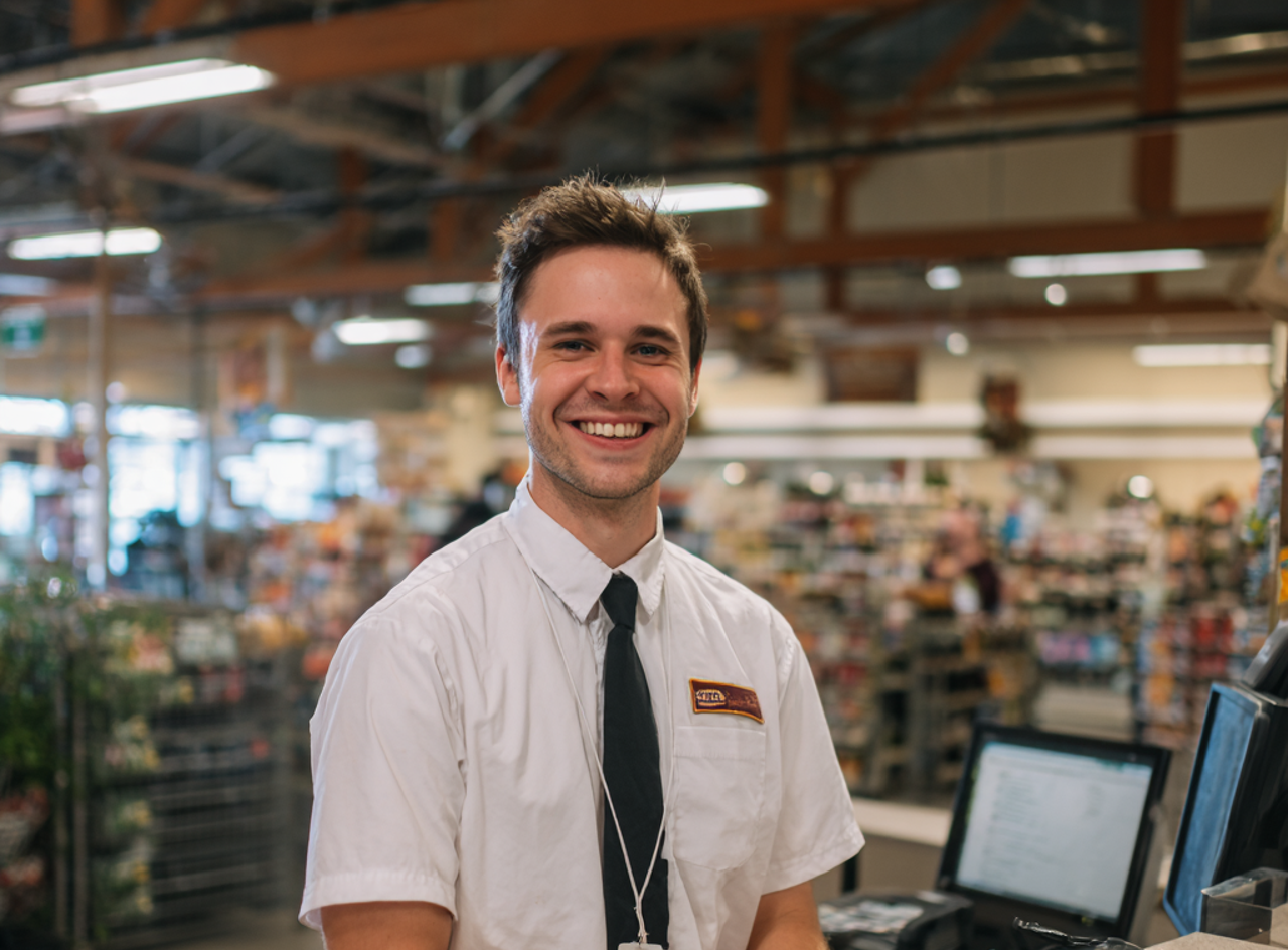 Un responsable de magasin souriant | Source : Midjourney