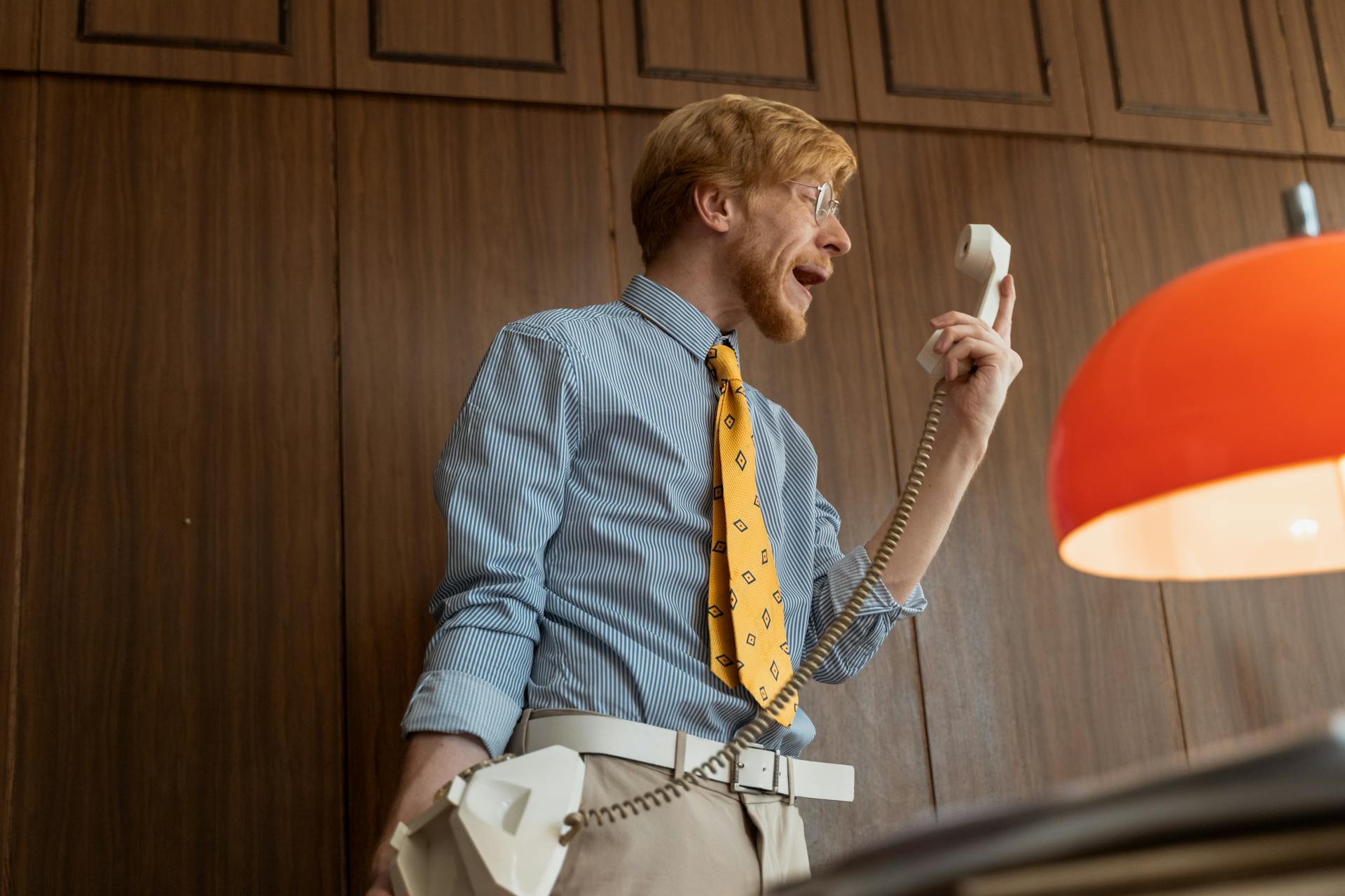 Un homme qui crie en tenant un combiné téléphonique | Source : Pexels
