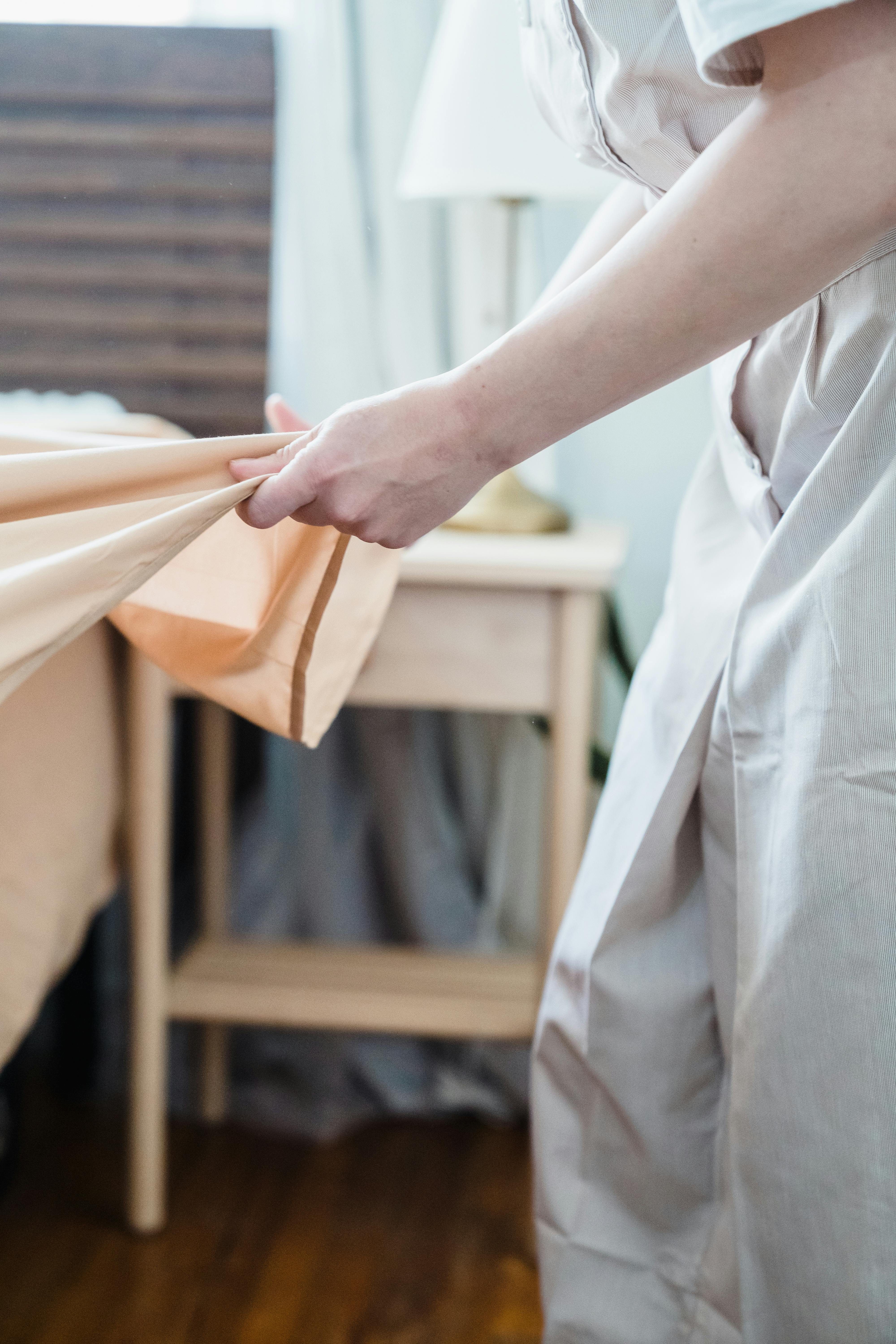 Une femme en train de plier un drap | Source : Pexels