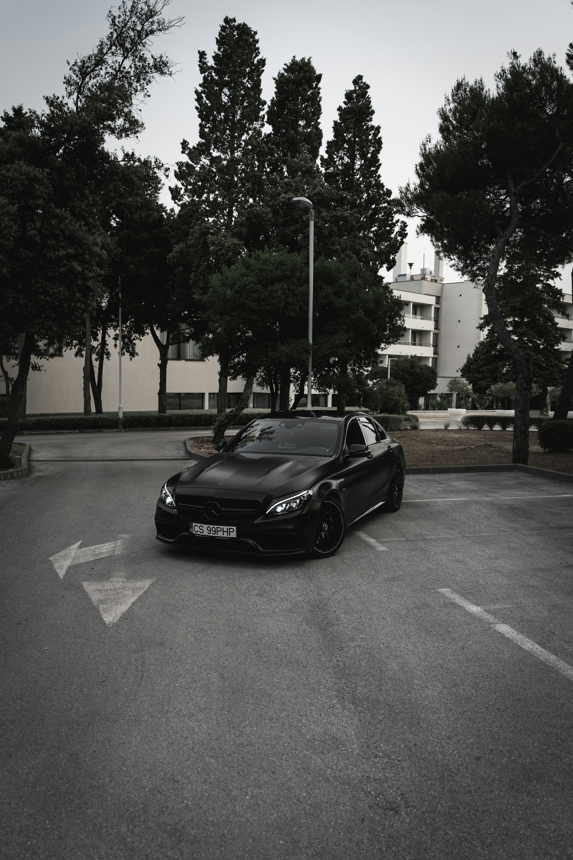 Une voiture noire garée sur le parking à l'extérieur d'un bâtiment | Source : Unsplash