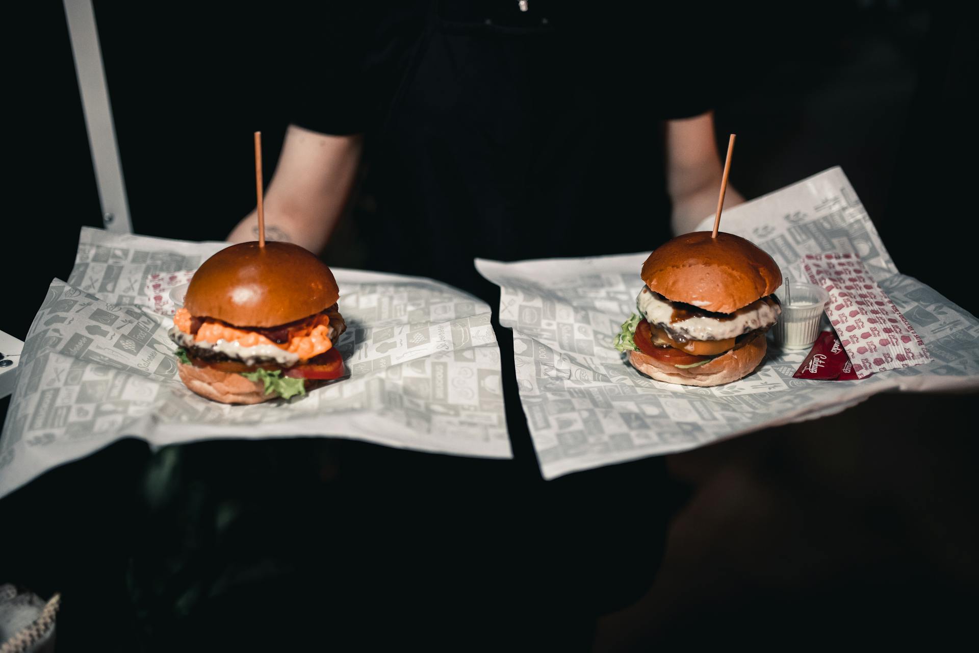 Un serveur portant deux hamburgers | Source : Pexels
