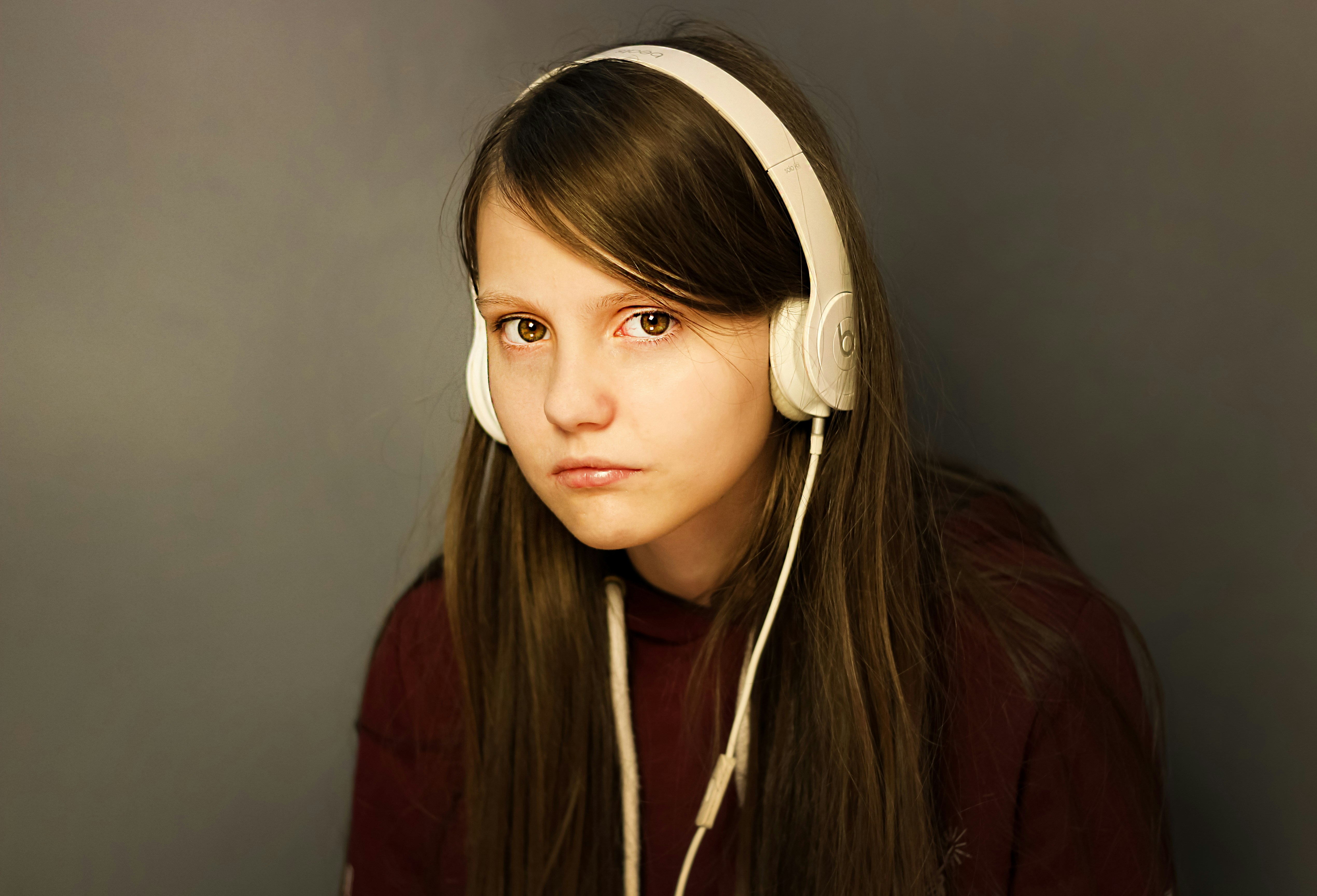 Une adolescente émotive portant des écouteurs | Source : Unsplash