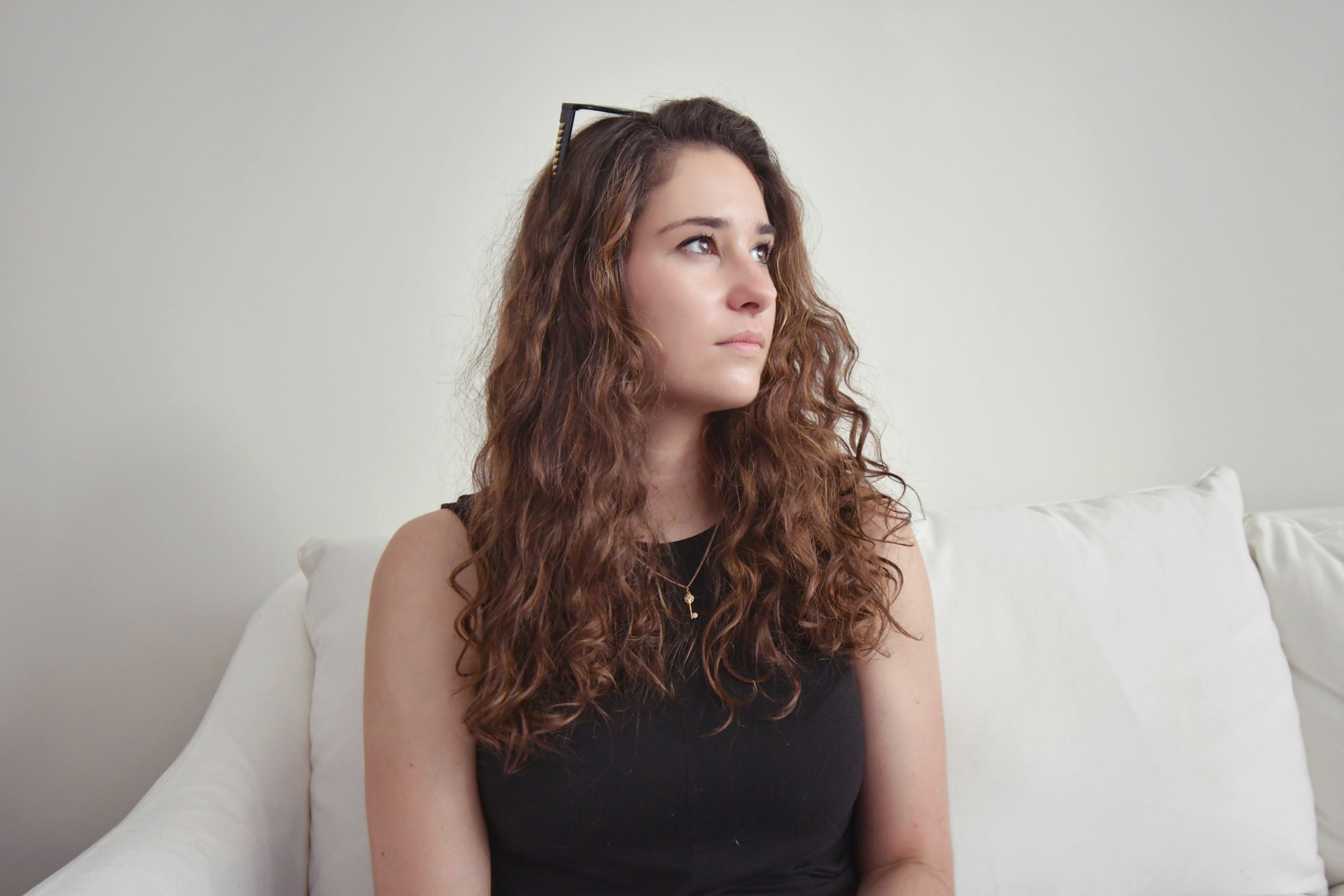 Une femme assise sur un canapé et regardant de côté | Source : Unsplash