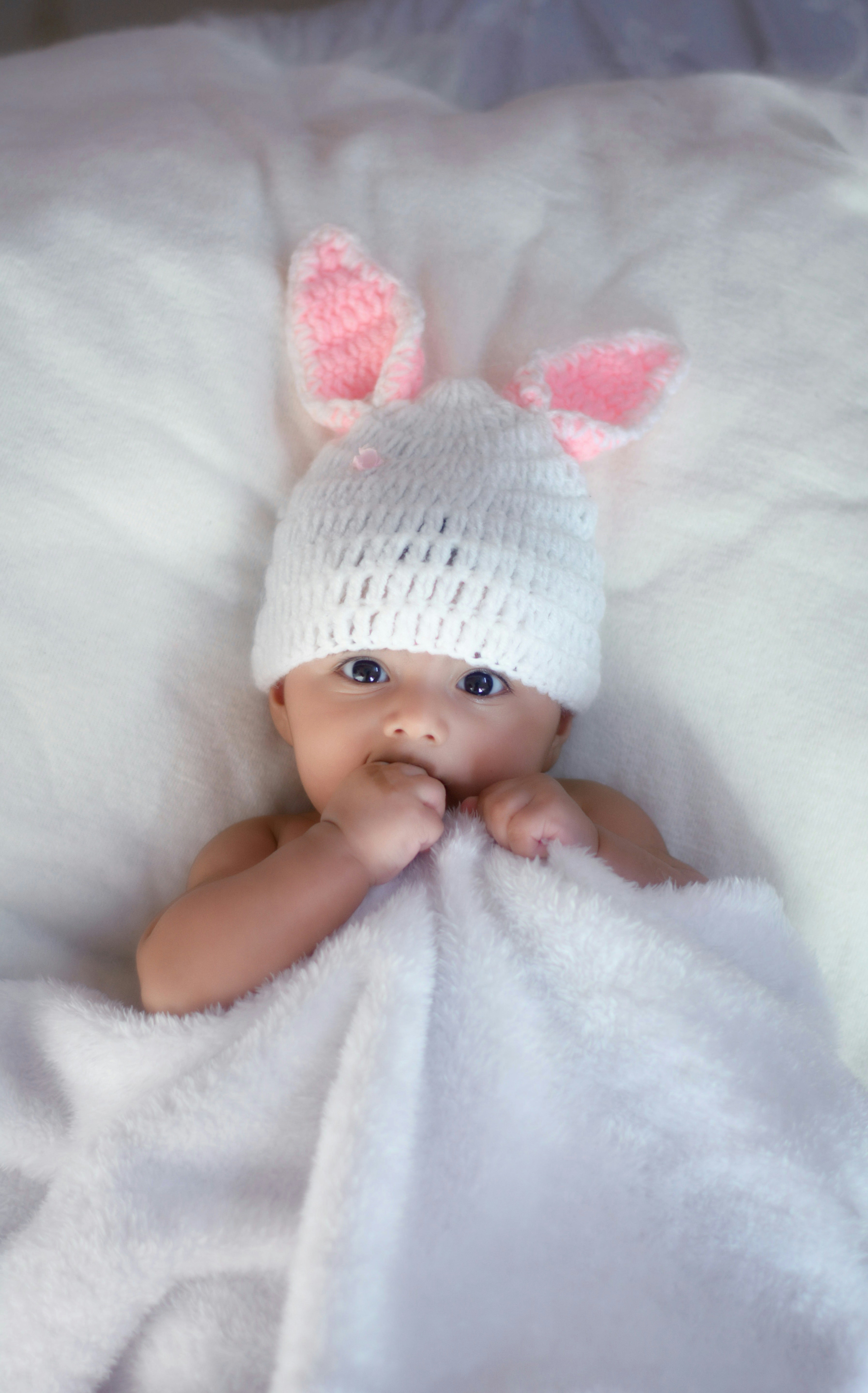 Une petite fille avec un bonnet en tricot blanc | Source : Unsplash
