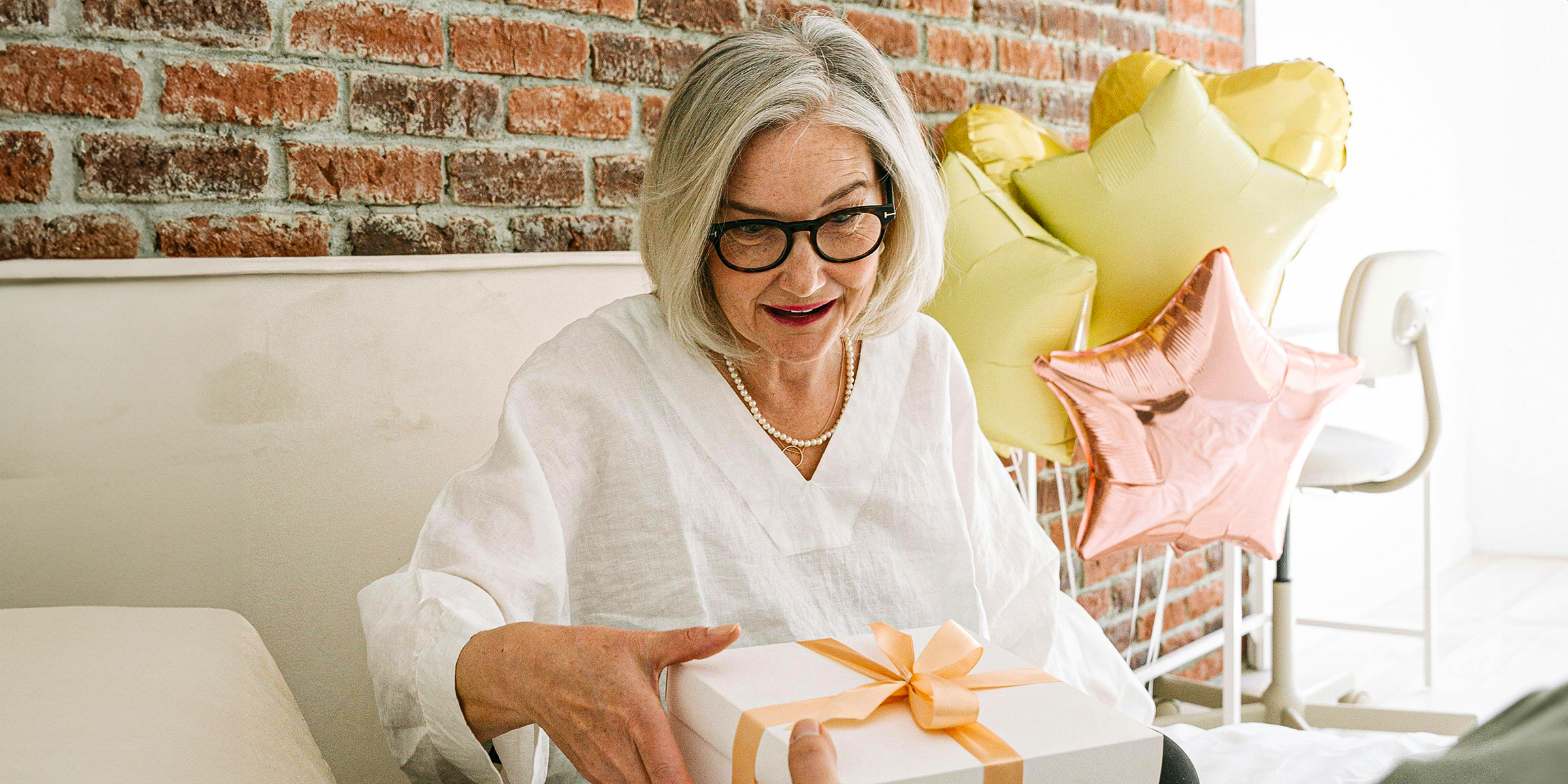 Une femme âgée qui ouvre un cadeau | Source : Pexels.com/ivan-samkov